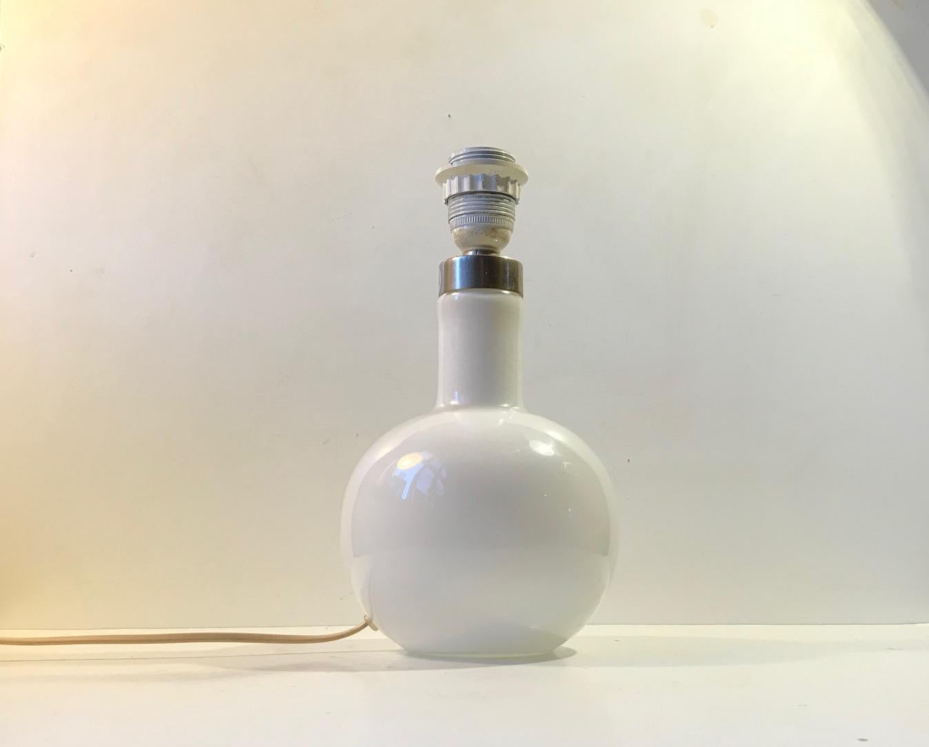 A vintage hand blown table lamp in cased white glass by Holmegaard Denmark. Designed in-house at Holmegaard in Denmark during the 1970s. Beautiful intact and working condition. Notice that the shade is not included. Please personalize by picking