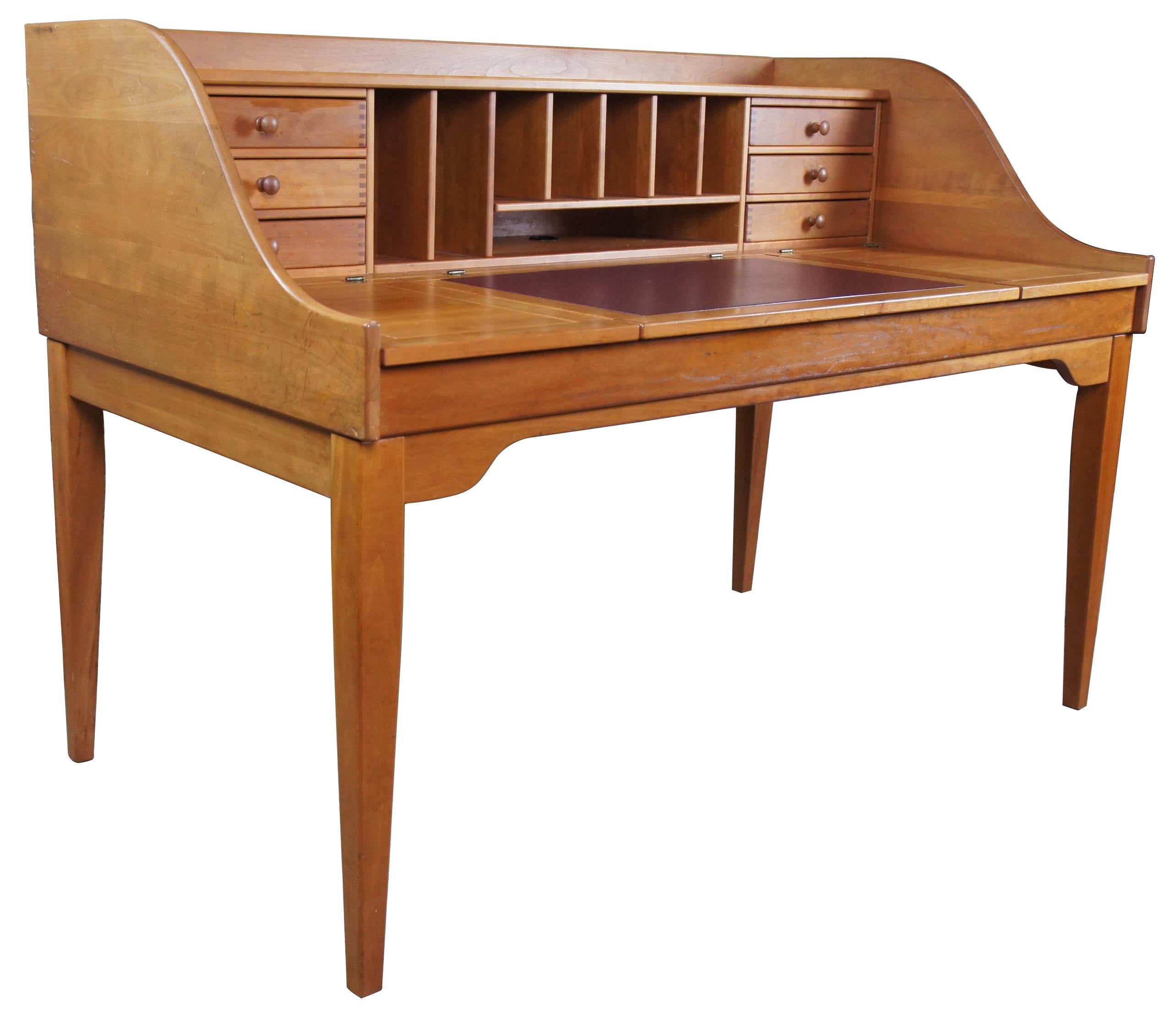 An incredible desk by Holmes County Chair Company. Made from solid cherry with a minimalist streamline shape. Features six fingertailed drawers along the back and cubbies for storage. Table surface is leather lined along the center and features dual