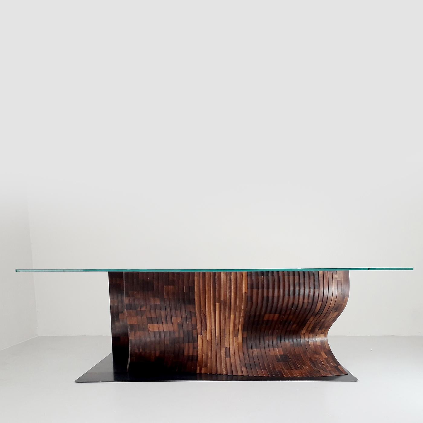 This unique table features a visually striking contrast between volume, shape and material. Its barely there, geometric, extra-transparent top stands against its large, undulating base in Canaletto walnut with a checkerboard motif, creating a look