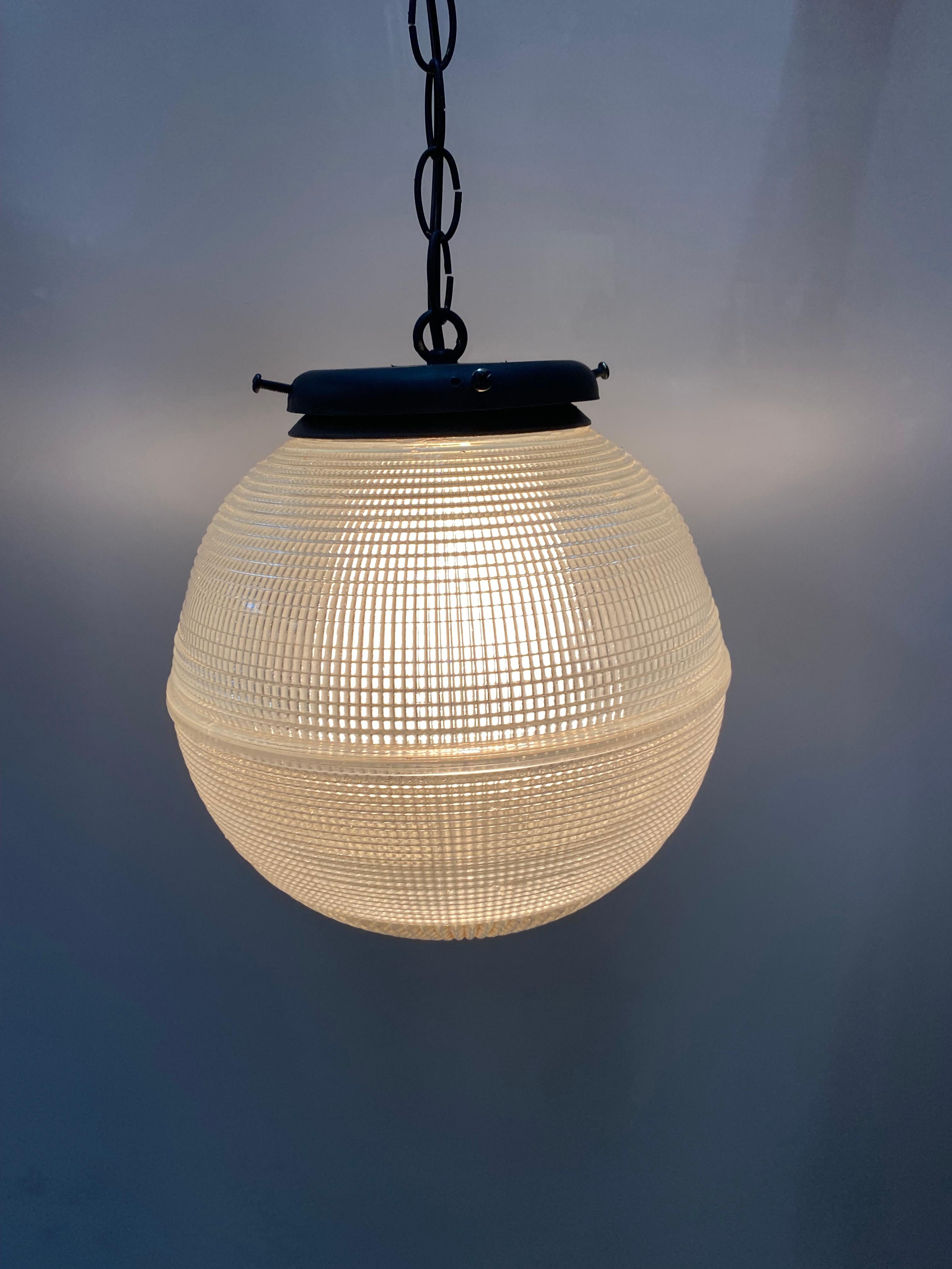 Create a beautiful ambiance with our vintage Holophane ball ceiling glass globe pendant. Originally created in 1898, these globes were popular all the way through the 1950s. The hallmark of Holophane light fixtures is the crosscut prism glass known