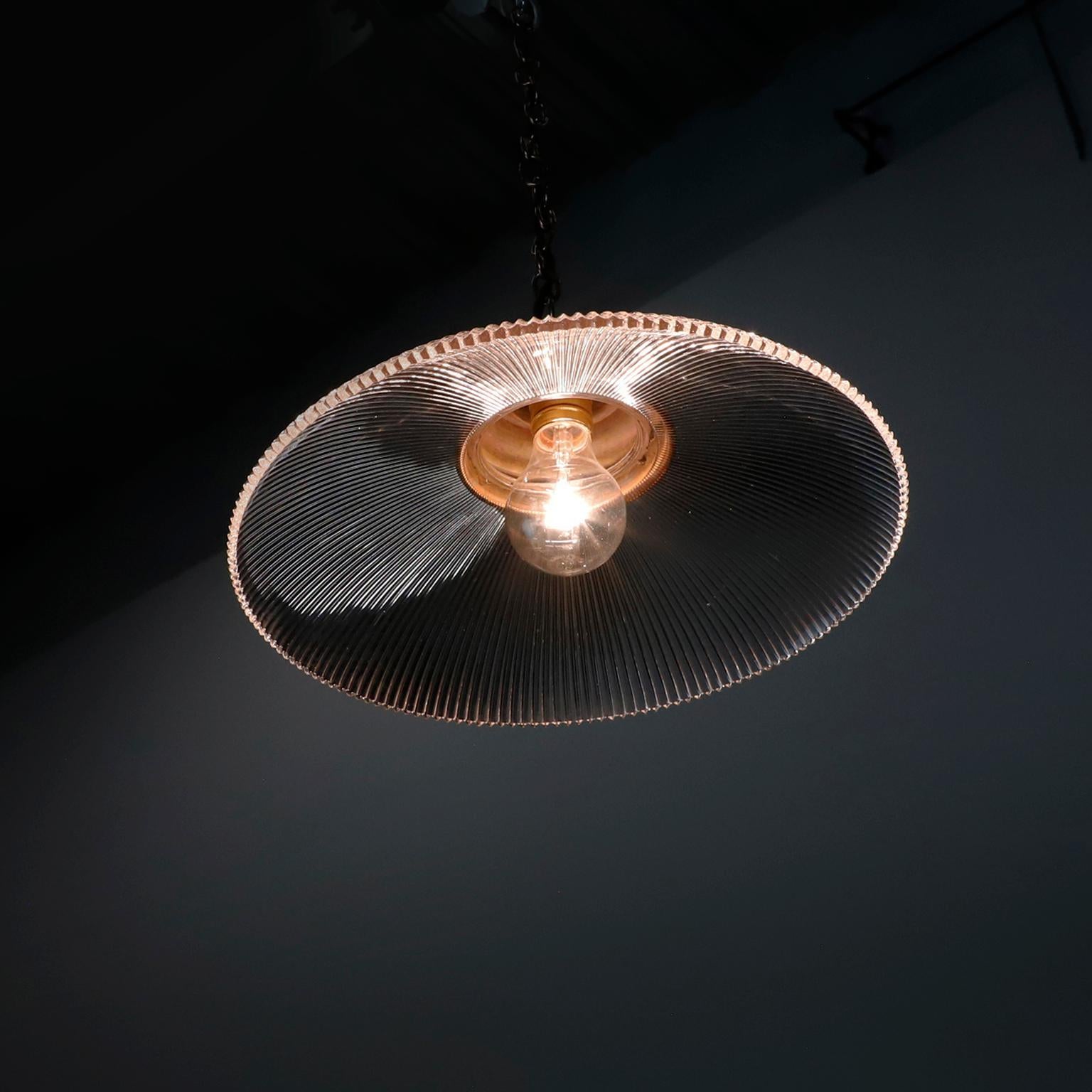 Offriamo questa lampada a sospensione industriale vintage in vetro trasparente Holophane. Paralumi in vetro prismatico in ottime condizioni. L'impianto elettrico è nuovo e funziona perfettamente.