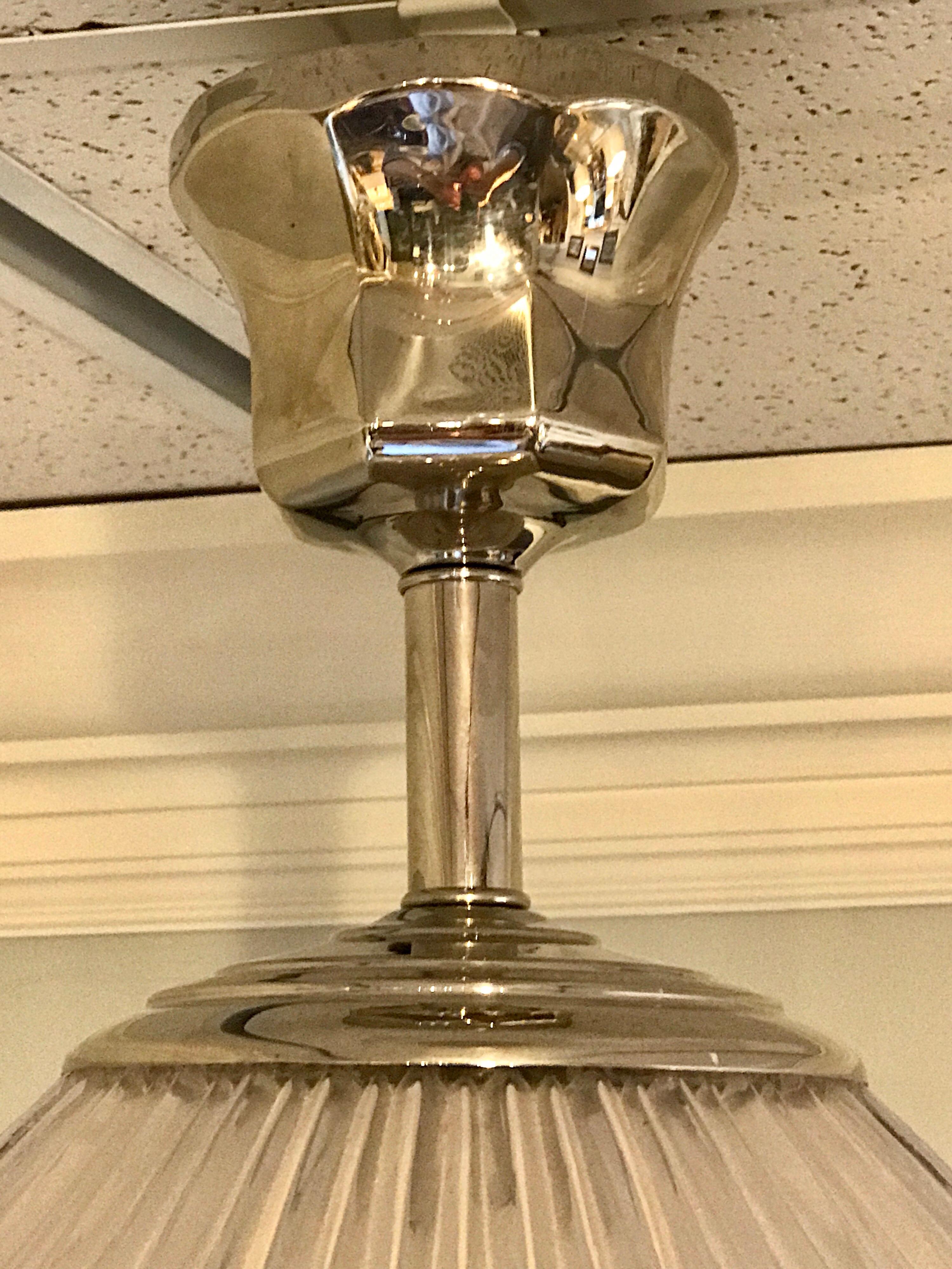 Polished nickel holophane glass pendant, with stylized mounts, good size vintage holophane glass shade, takes one standard bulb. Shown as a flush mount, chain can be added. Newly wired.
The shade alone measures 18