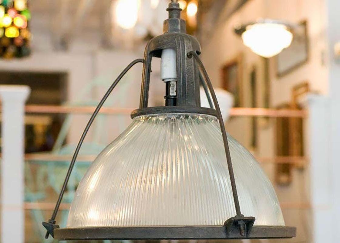 Diese industrielle und doch elegante Hängelampe aus den 1940er Jahren hat einen Holophane-Glasschirm. Die Pendelleuchte ist mit einem Aluminiumgehäuse verbunden, das an der Oberseite der Leuchte befestigt ist.

Eine Holophane-Glas-Deckenleuchte ist