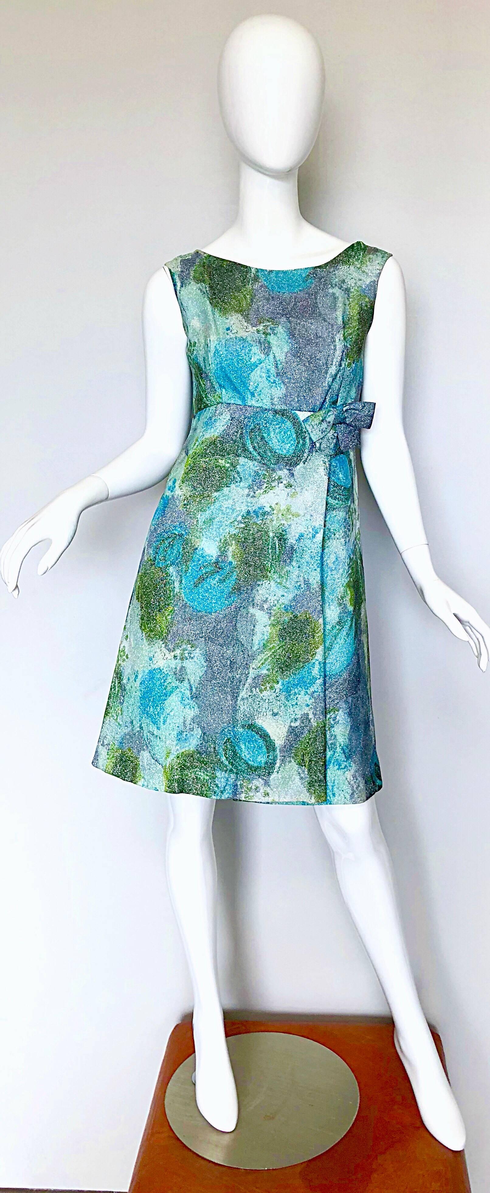 Chic 1960s HOLT RENFREW demi couture silk lurex blend A-Line dress! Features vibrant watercolor prints throughout. Tailored fitted bodice, with a slightly flared skirt. Pre-tied bow under front left center bust. Three gunmetal silver engraved