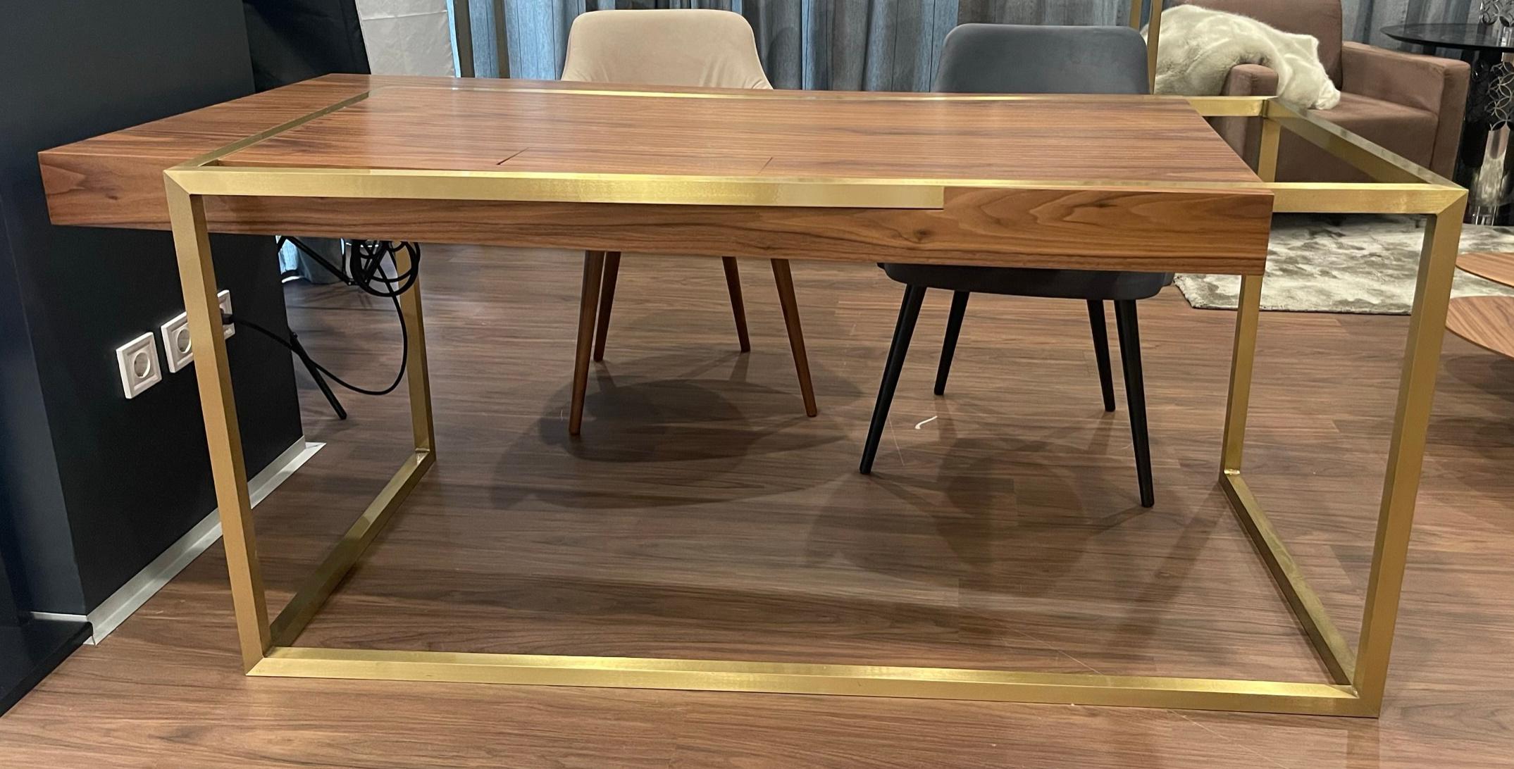 The Executive Desk ExCentric 2.0 listed here is made in walnut wood and brushed brass. The desk has two drawers, electrical plugs, and a wireless phone charger.
The piece is in excellent condition and was used as display furniture in our showroom in