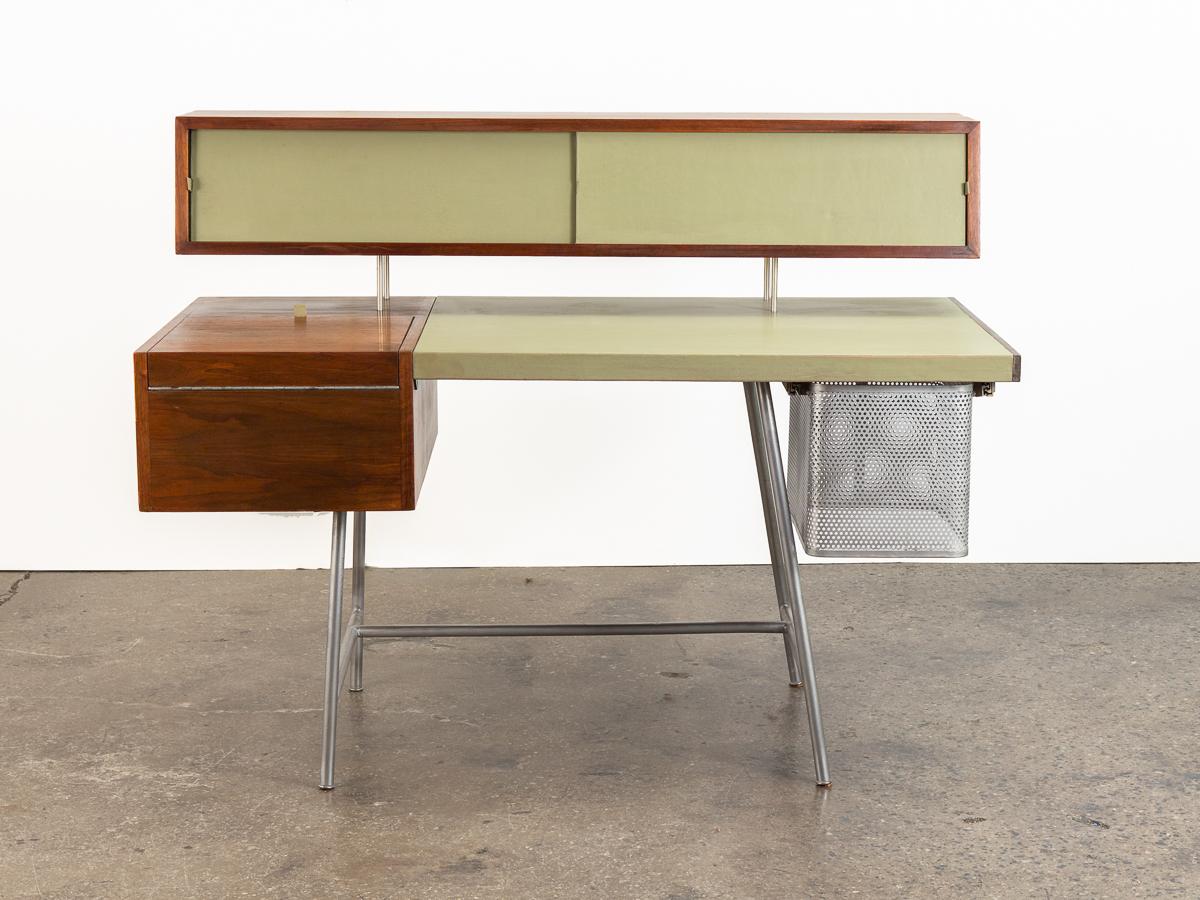 Home office desk model #4658 by George Nelson for Herman Miller. Floating back features leather covered doors with shelves inside. Fold-out compartment extends the work surface and reveals neat pull-out drawers and additional shelving within.