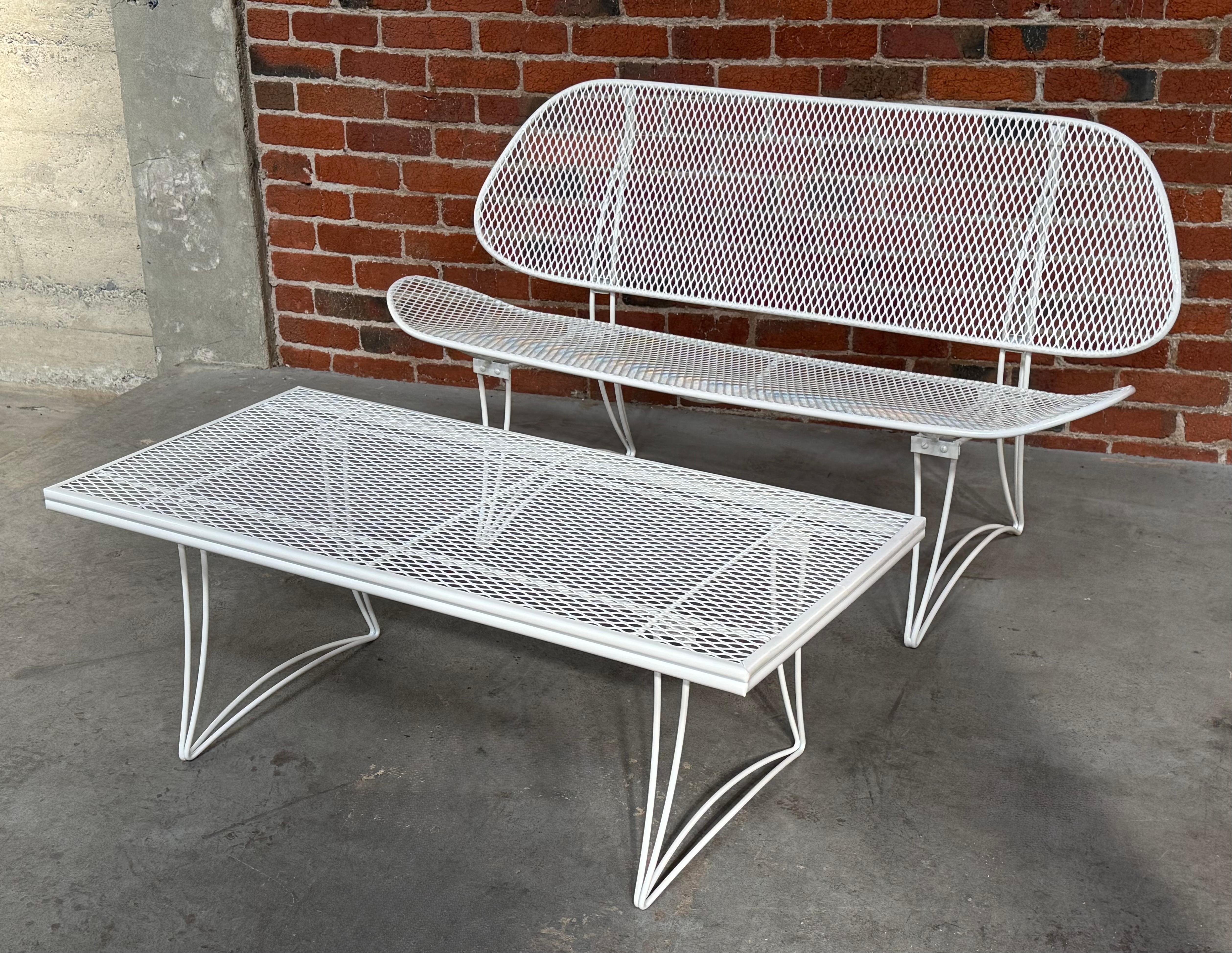 Homecrest settee and coffee table patio furniture set. Expanded metal and iron framed construction that has been recently restored, bead blasted and power coated in a off white to withstand the elements. The coffee table measures 42
