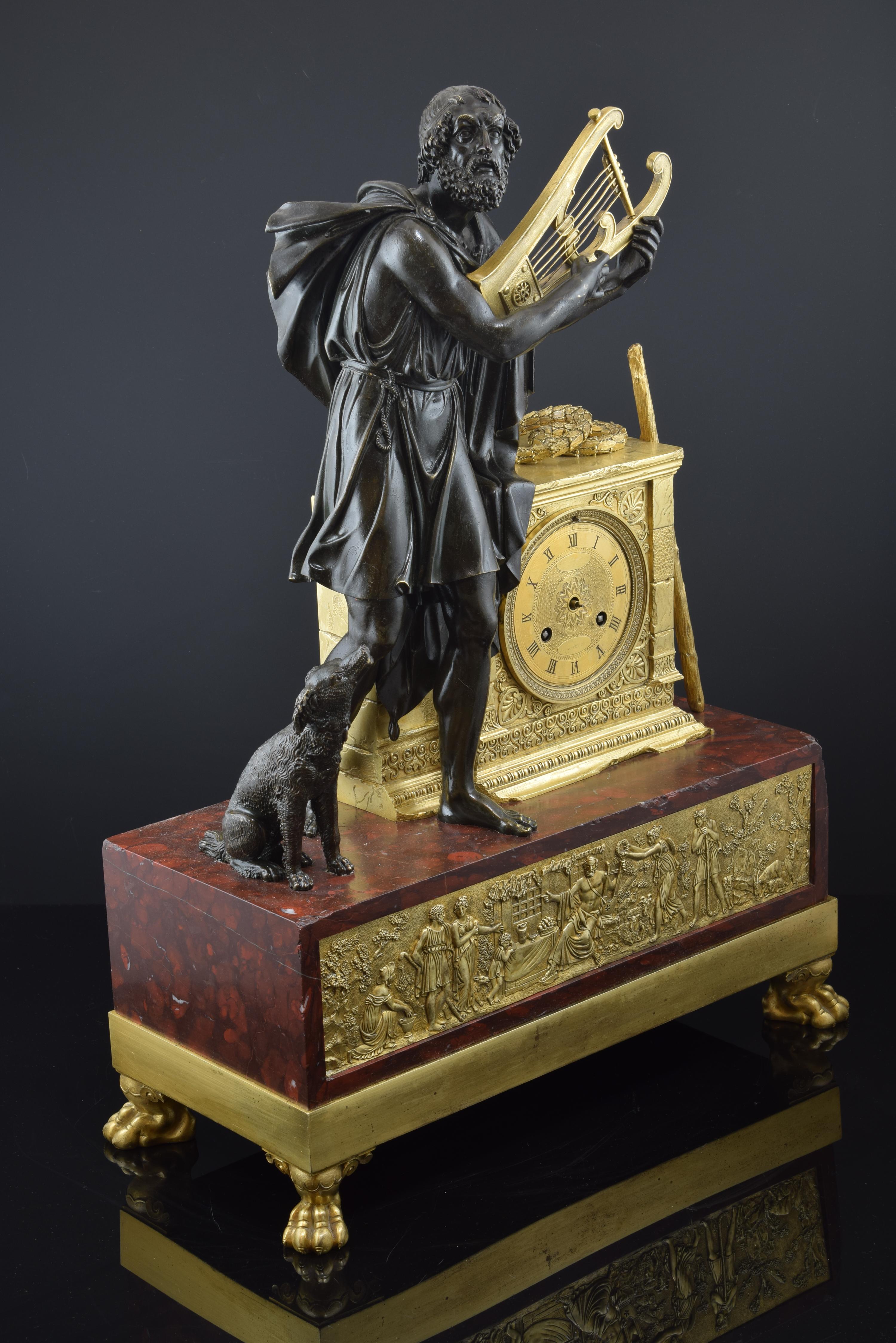 Requires restoration.
Table clock made of bronze with a piece of veined marble in dark red. This one serves as a pedestal, and is raised on a smooth bronze band with beast claws in the corners as legs, and that has a front decorated with a delicate