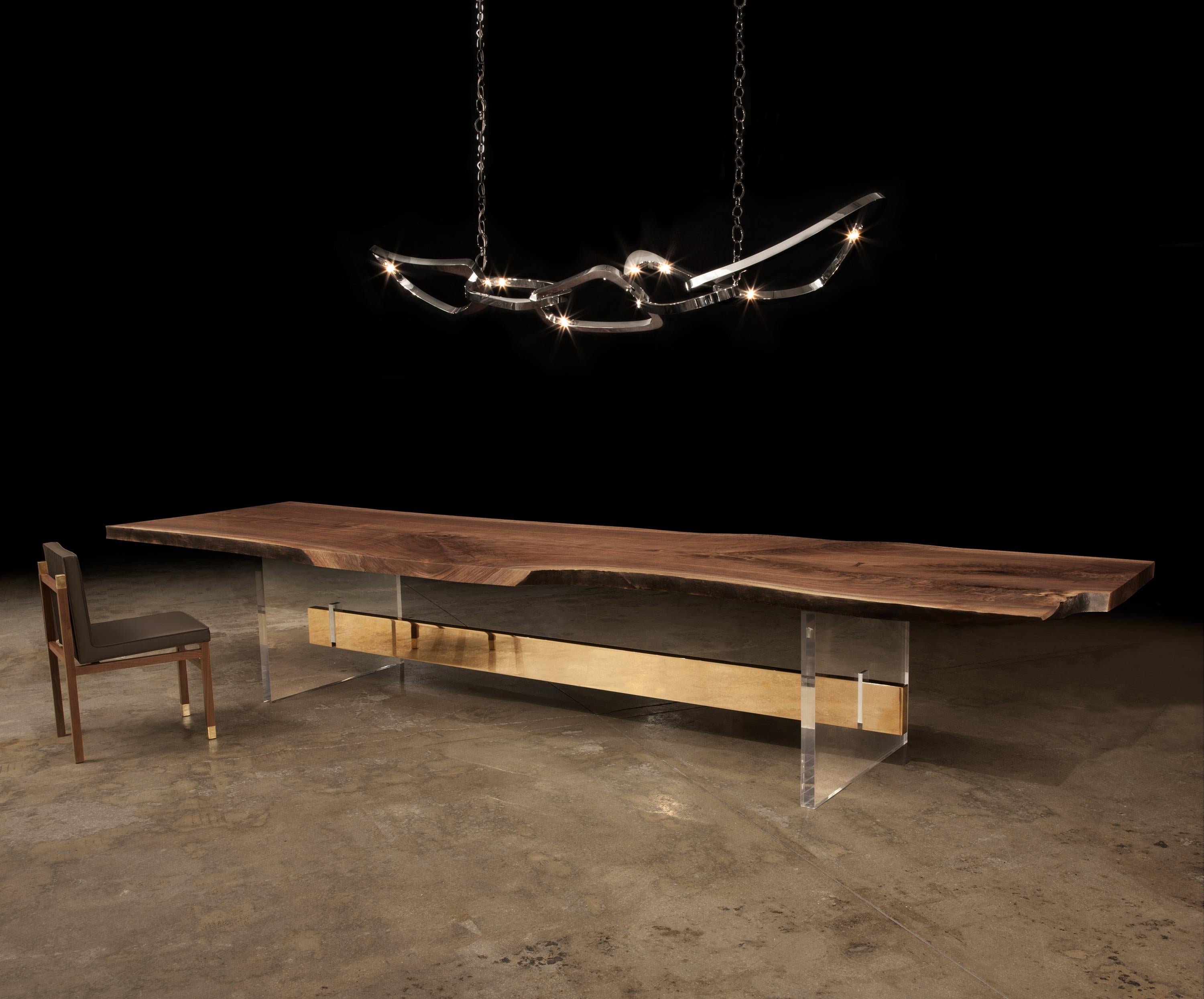 Utilizing an artful combination of modern materials, the Barlas Baylar Hommes Dining Table’s Plexi legs and Bronze or Stainless stretcher add structure and character to any setting.  

The table is completed with a solid-slab, Live Edge Walnut top