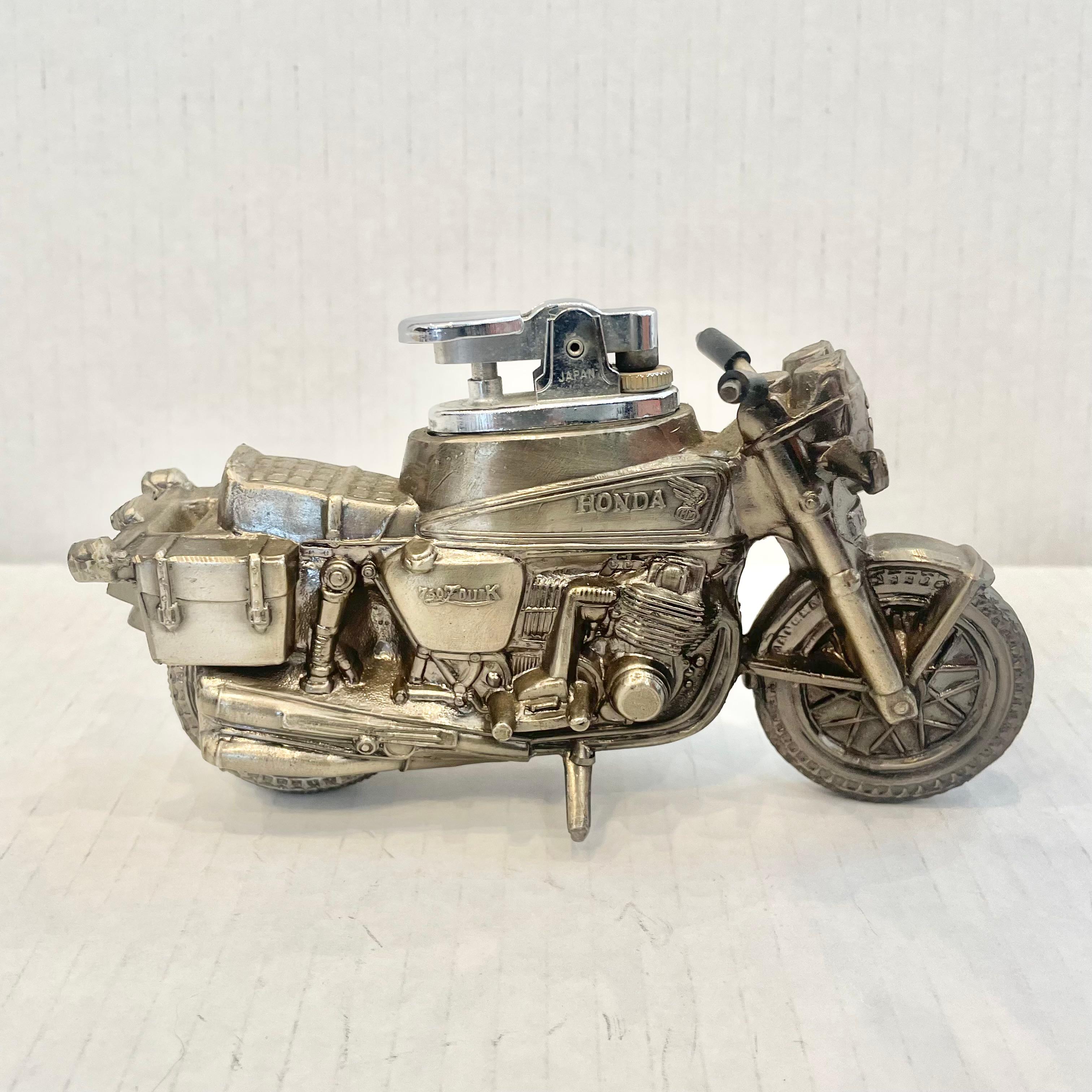 Vintage table lighter in the shape of a Honda CA 750 Dream. This great cafe racer style body is made completely of metal with a hollow body. Light patina giving this piece a classic silver color. Cool tobacco accessory and conversation piece.