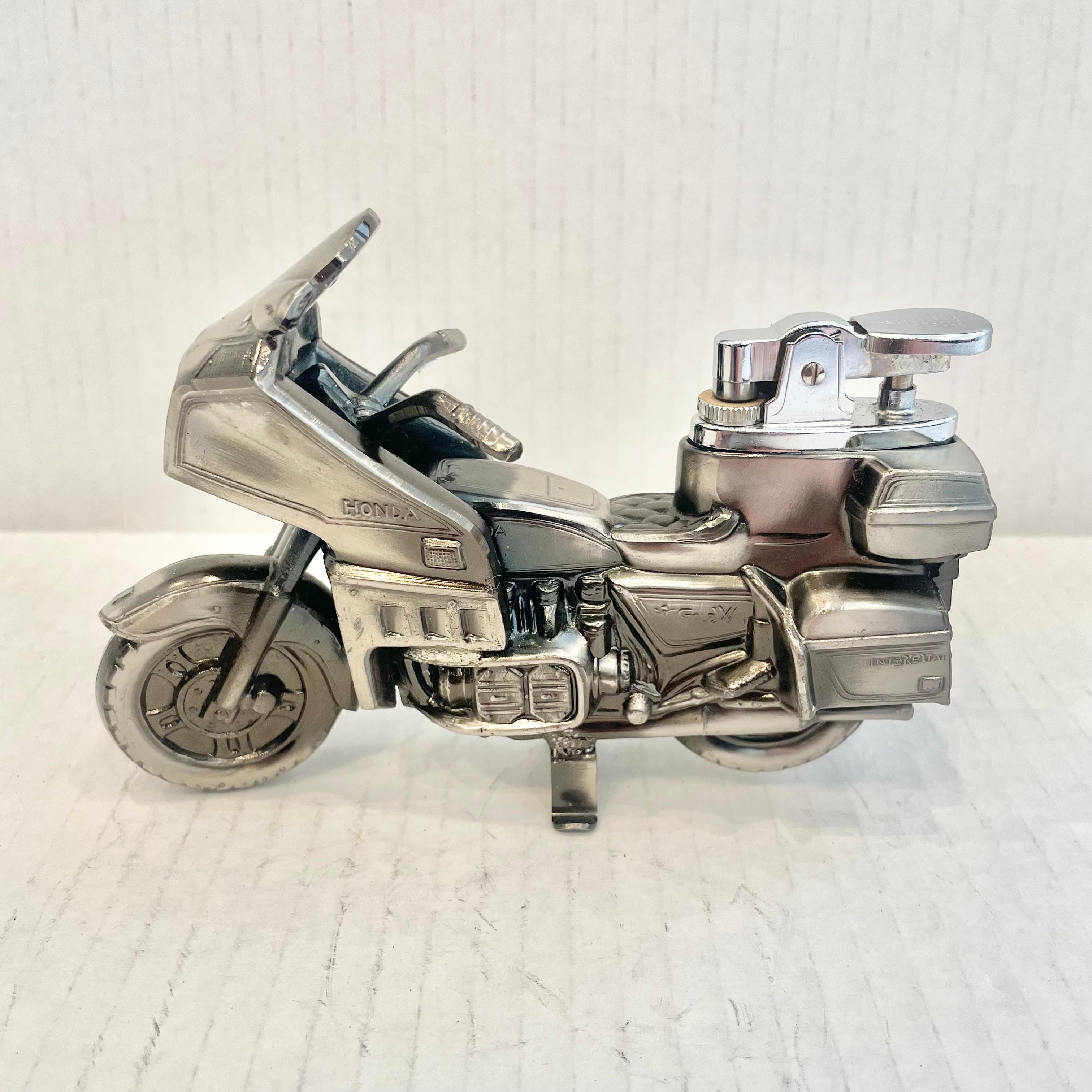 Cool vintage table lighter in the shape of a Honda Gold Wing motorcycle. Made completely of metal with a hollow body. Beautiful burnished silver color with intricate details. Cool tobacco accessory and conversation piece. Working lighter. Very