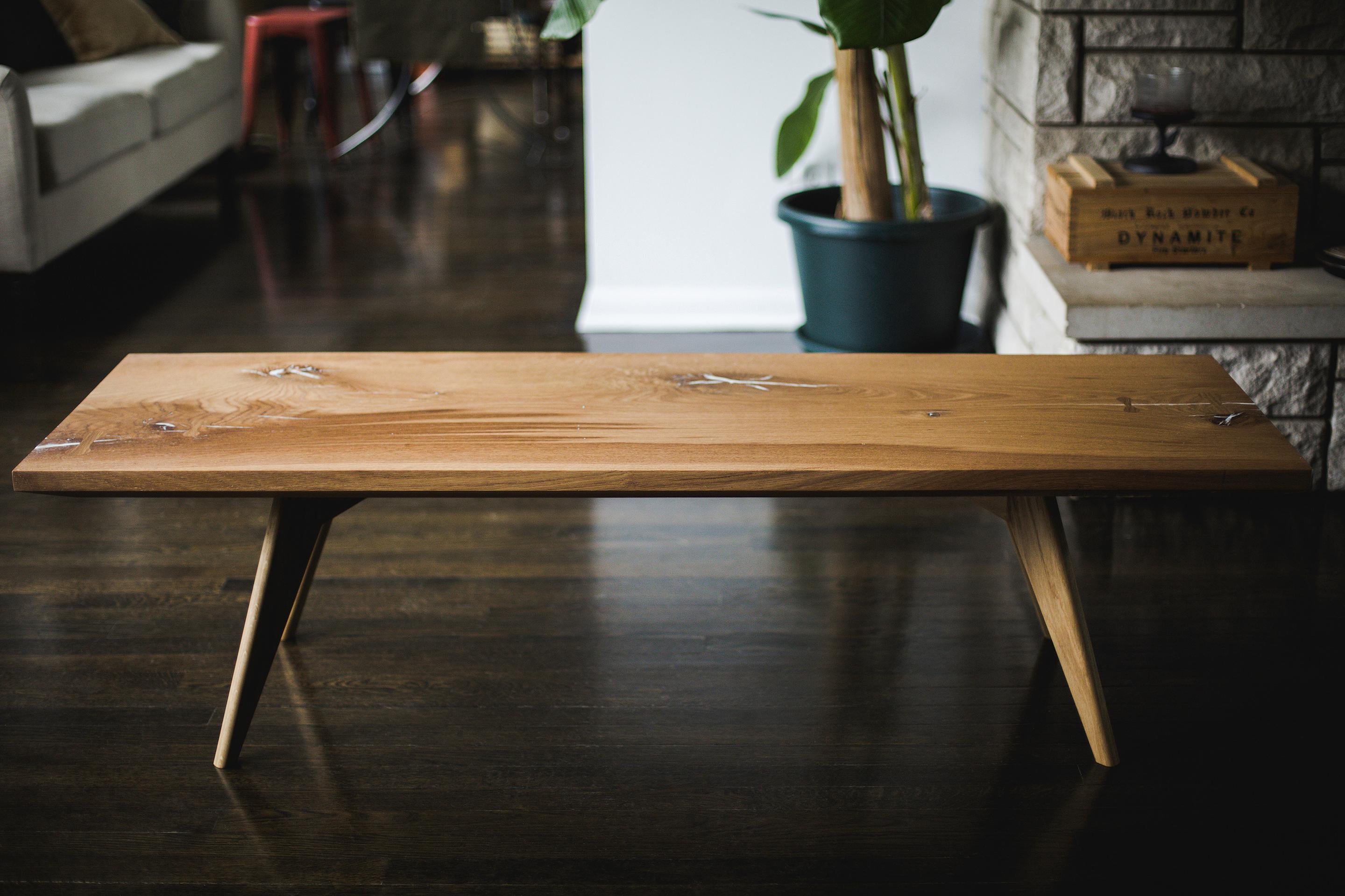 Une table basse moderne / un banc formé d'une seule dalle ou de planches multidimensionnelles. 
Les chèques et les nœuds sont remplis d'une résine époxy blanche opaque et renforcés par des incrustations de clés en chêne blanc.
Construction et