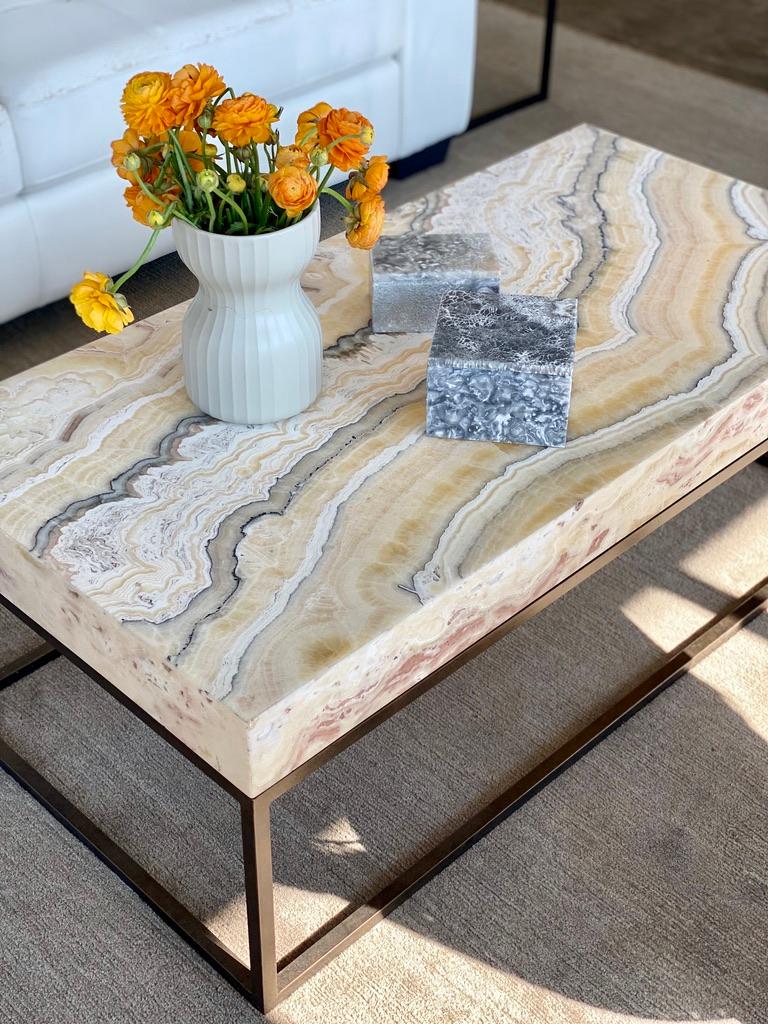 Mesmerizing bands of mineralization run the length of this table in a range of neutral earth tones, including taupe, gray and yellow, resulting in a one of a kind showstopper centerpiece for a room. The table base, made of forged iron, is finished