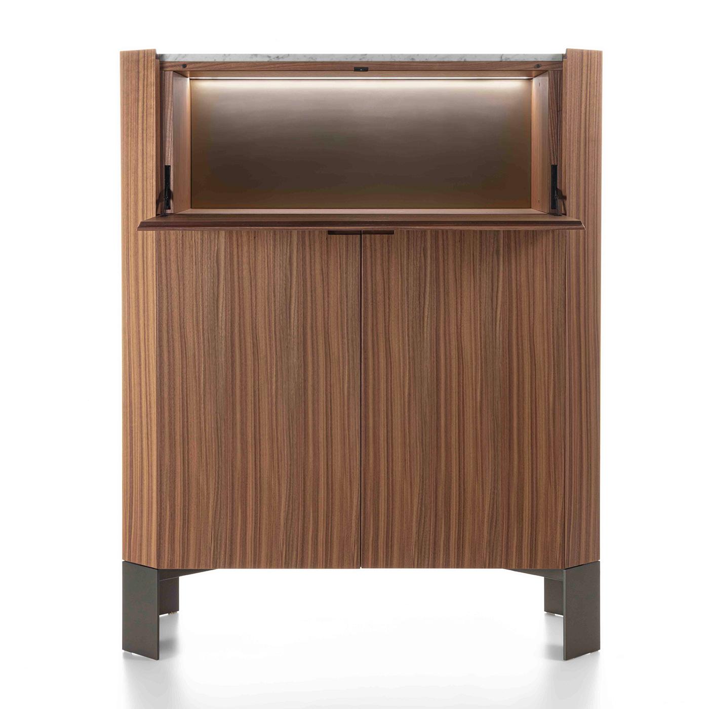 This remarkable bar cabinet in solid Canaletto walnut is distinguished by its characteristic warm tone and rich grain. A cabinetmaking gem brimming with geometric inspiration, the entire structure features a rigorously-sculpted profile that pools