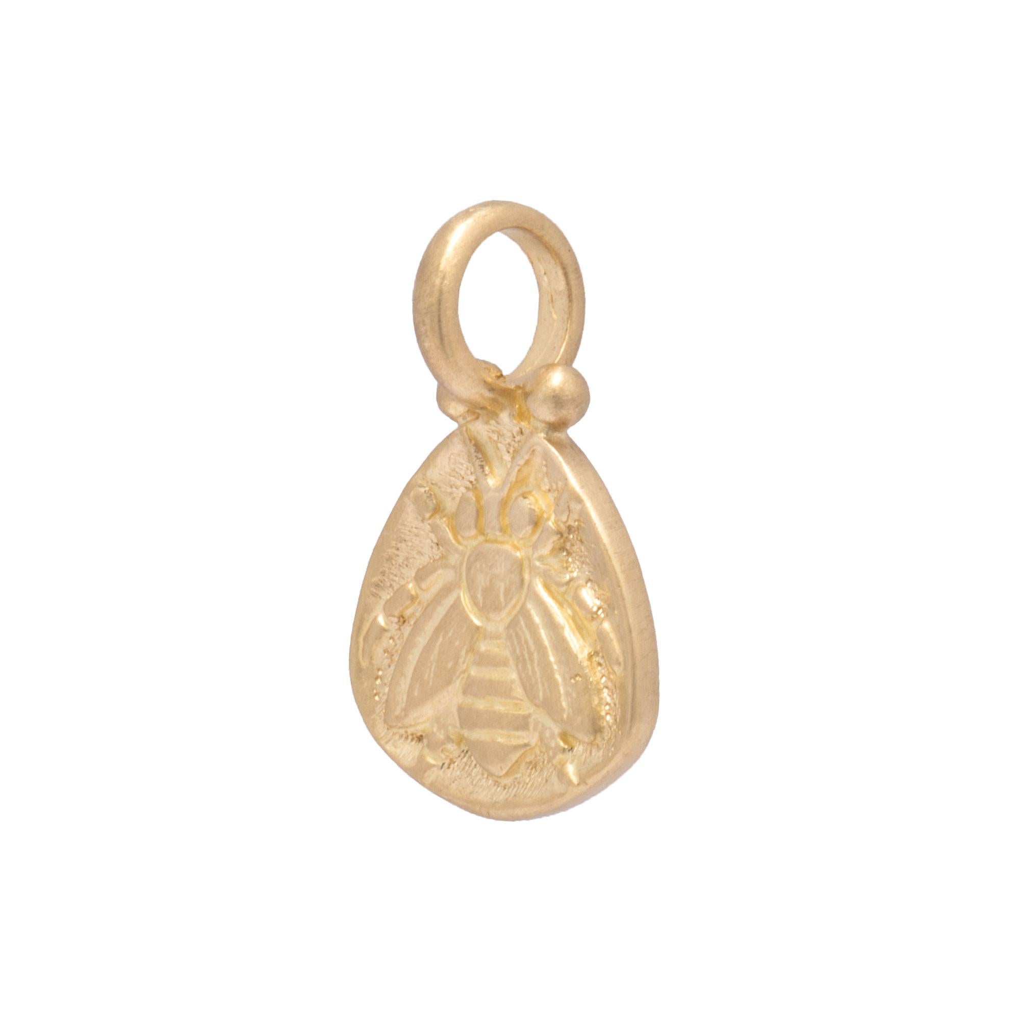Our Honey Bee Amulet is a regal emblem of femininity in handcrafted 18k gold. Finely carved and finished in a rounded triangular pendant with 2 gold beads on either side of the rounded bail, this pendant can be worn alone or with additional chain or