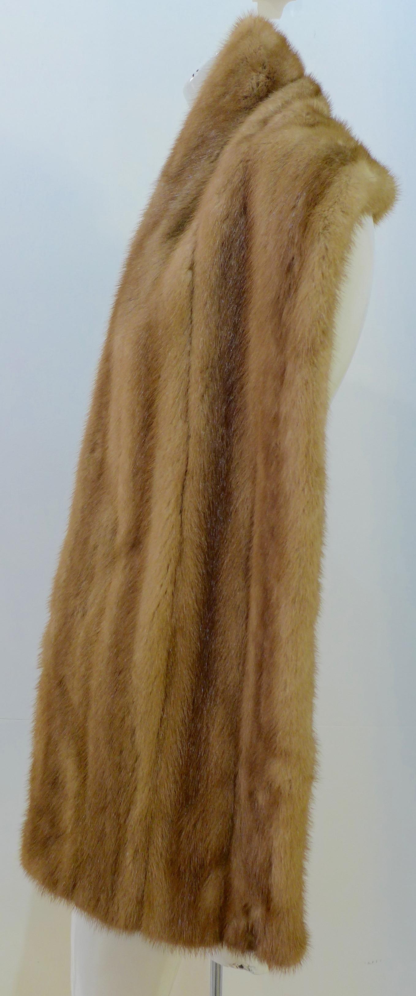 This real mink fur wrap is in great condition. It has a taupe satin lining and appliquéd monogram patches. 

Measurements in Inches:
Width: 11.5
Length: 72 