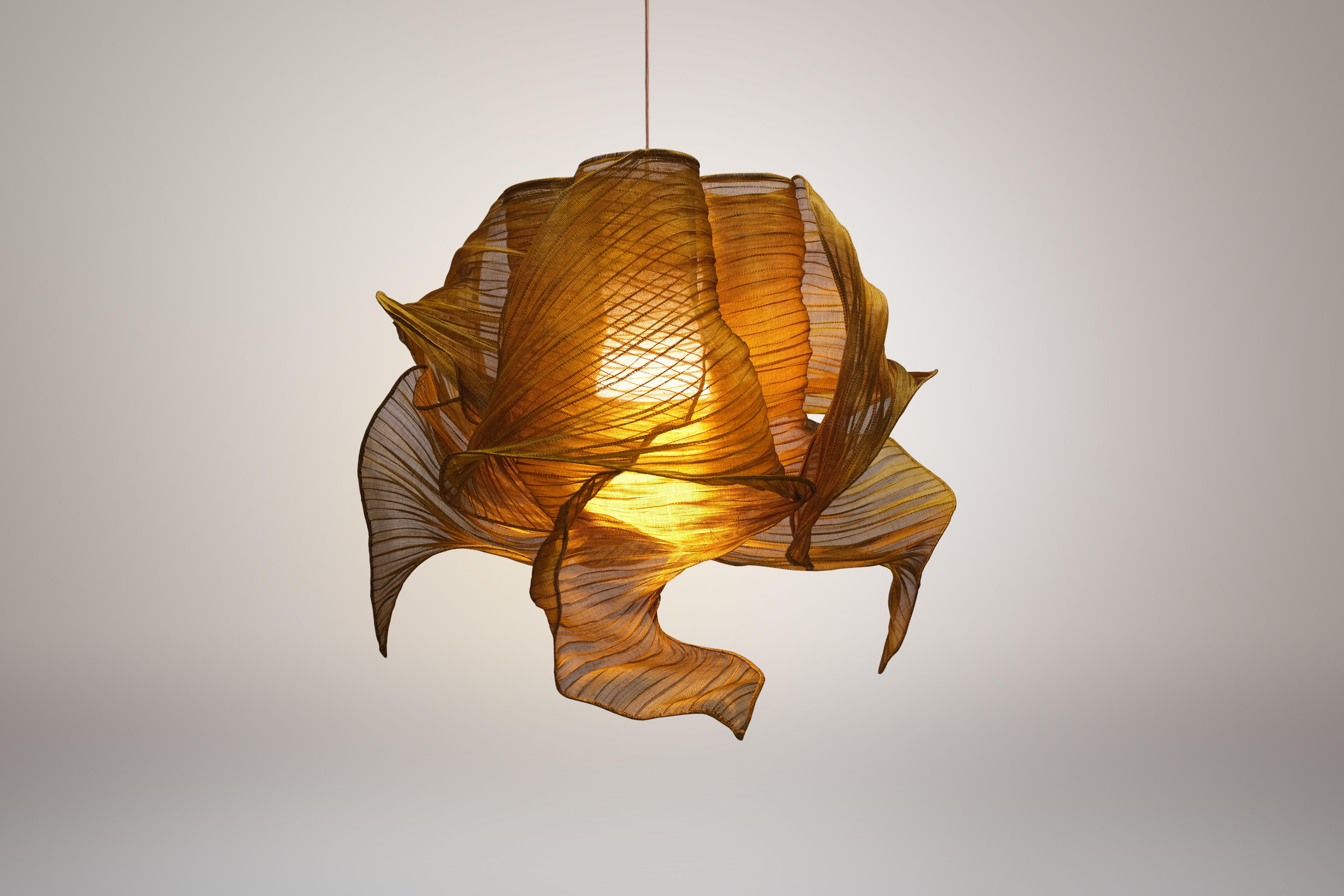Honey Nebula pendant lamp by Mirei Monticelli.
Dimensions: D 60 x W 60 x H 60 cm.
Materials: Banaca fabric.
Also available in hand-painted fabric.

Providing soft light in an organic and unique design, the Nebula Lamp draws its inspiration from