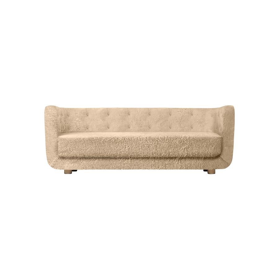 Honey sheepskin and smoked oak Vilhelm sofa by Lassen
Dimensions: W 217 x D 88 x H 80 cm 
Materials: Sheepskin, Oak.

Vilhelm is a beautiful padded three-seater sofa designed by Flemming Lassen in 1935. A sofa must be able to function in several
