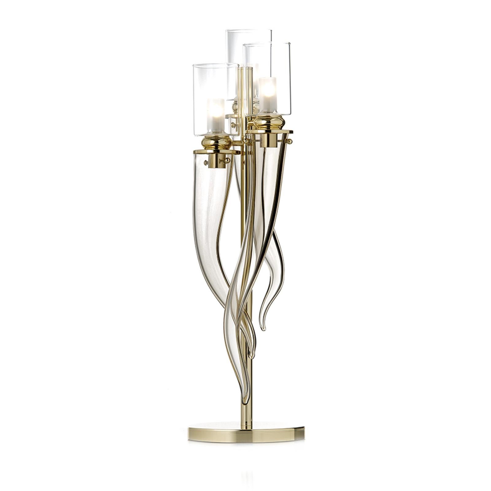 This striking table lamp will be an eye-catching addition to an entrance, a dining table, or a living room. The brushed and lacquered vertical metal structure with gold polish rests on top of a round base and stems vertically to support three