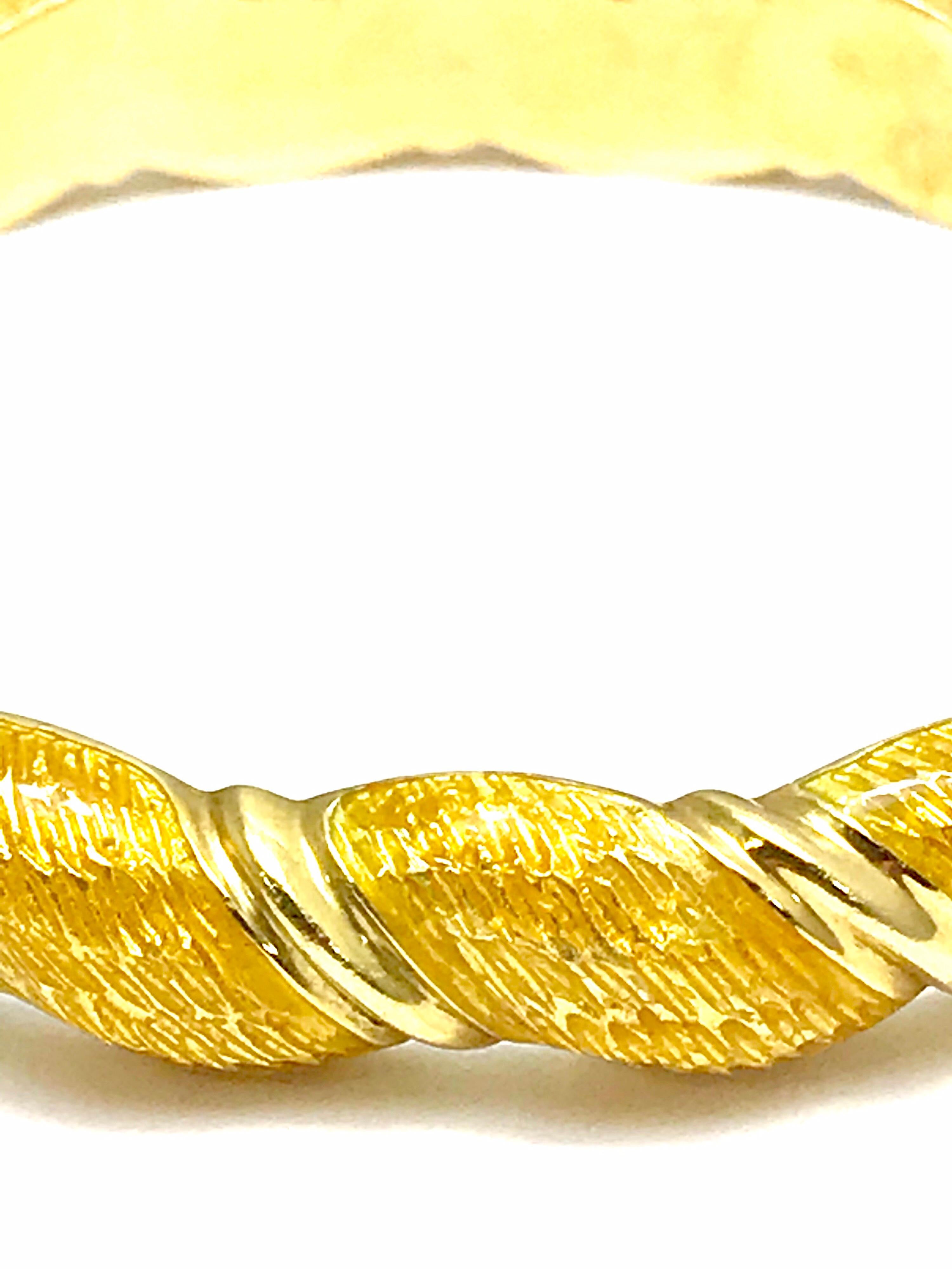 A beautiful honey yellow guilloche enamel and 18 karat yellow gold bangle bracelet.  The enmael has a textured finish with a wave of gold between sections to create the pattern.  The bangle is hinged, and has a push down clasp opening with a safety