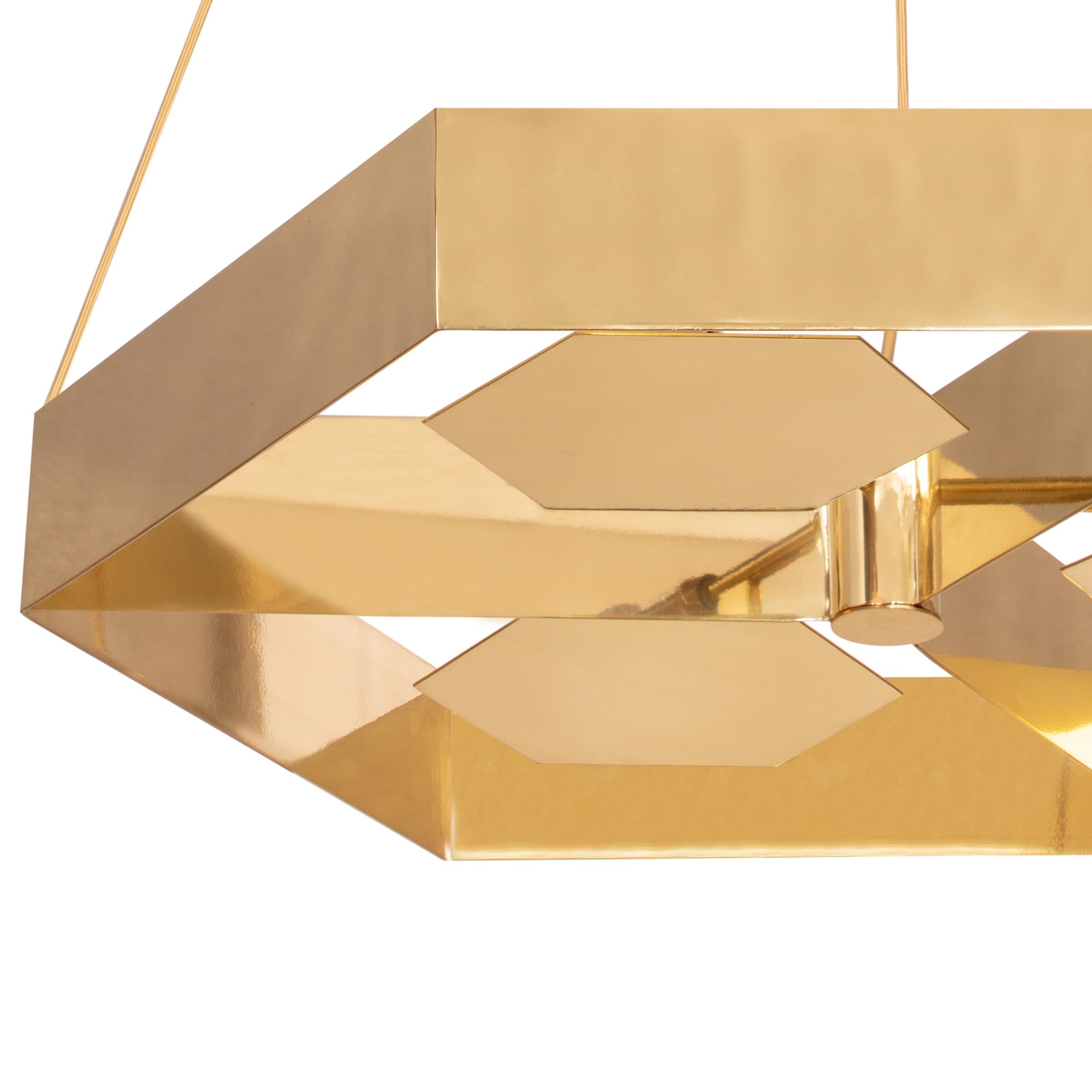 A suspended element with hexagonal shape projecting light to the ceiling creating a pacific lighting and comfortable ambience and a luxurious experience thanks to the metal shades used in this piece.

AS PICTURED
Body: Polished brass and Stainless