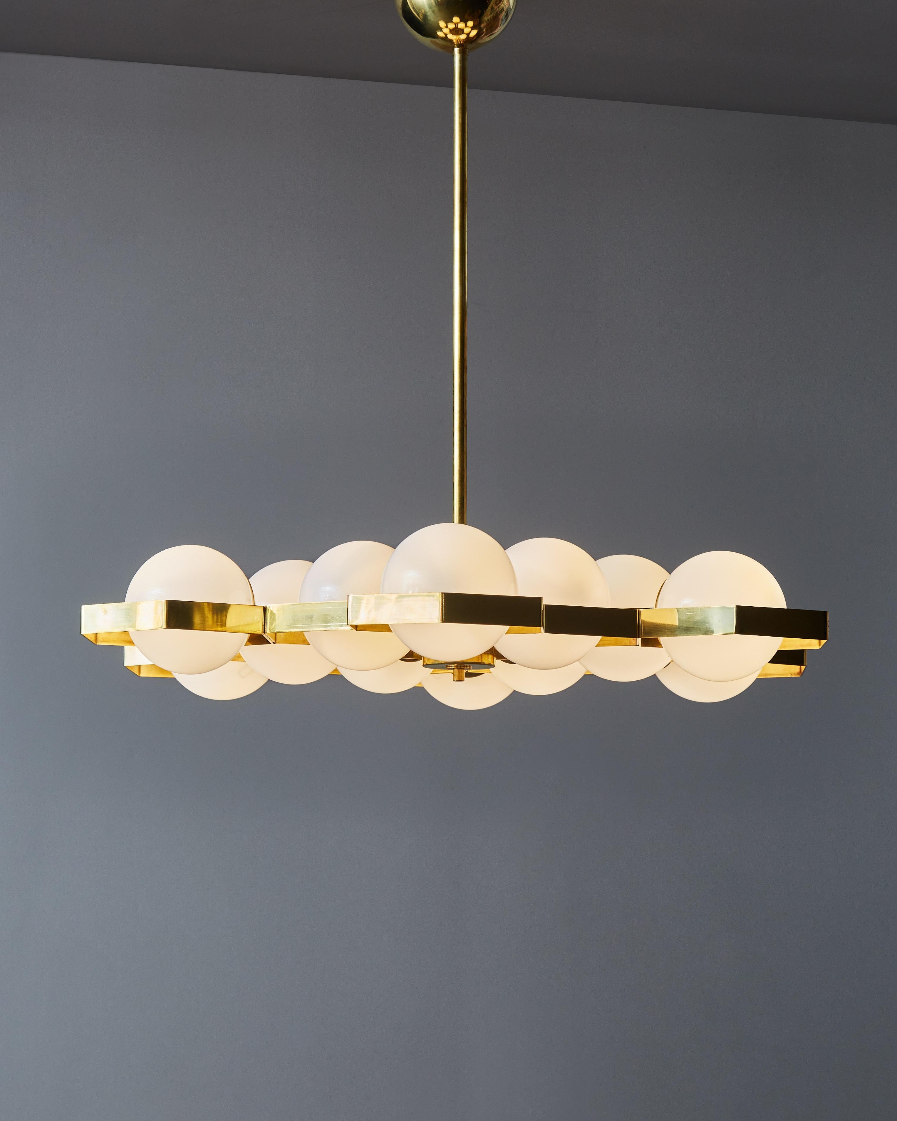 Honeycomb shaped brass chandelier with twelve light sources in opaline glass globes. The vertical rod can be removed to make the piece a flush mount.