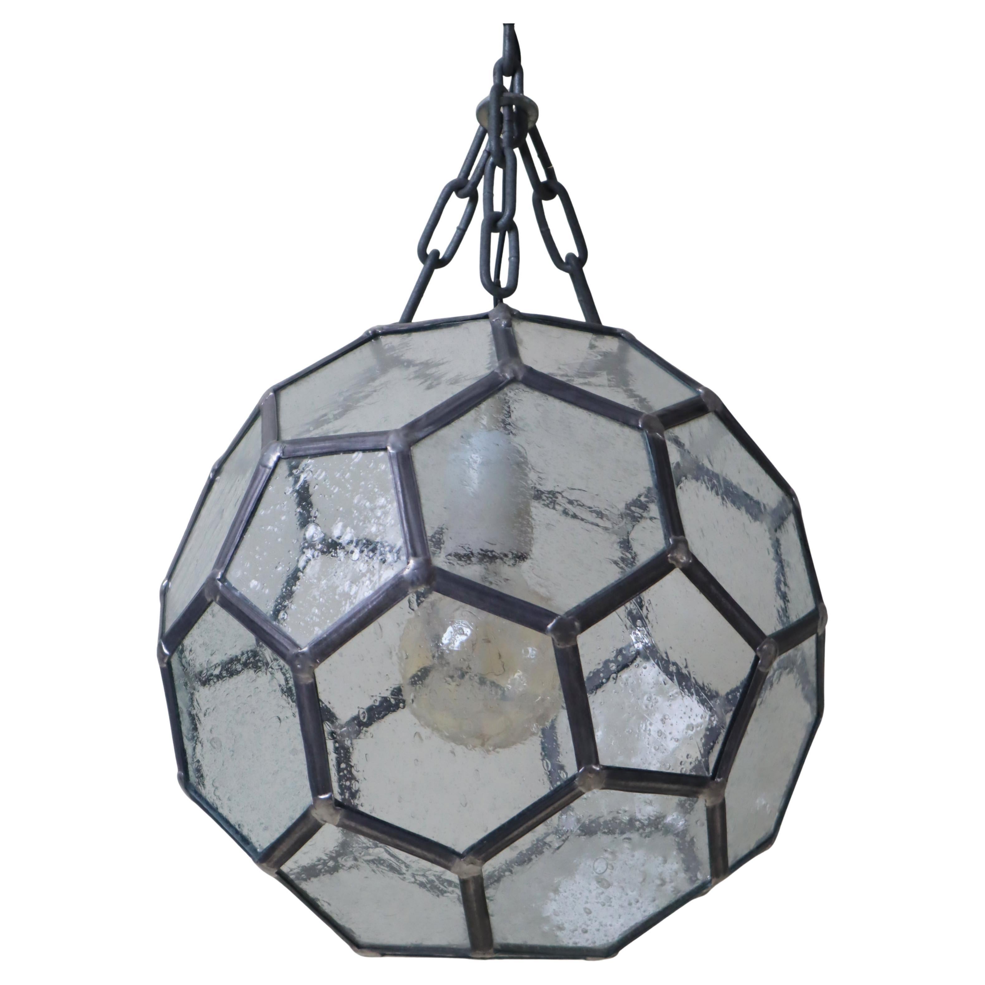 This beautiful geometric pendant lamp, crafted in the style of architect Adolf Loos around the 1950s, is sure to captivate you with its selection of exquisite materials, such as the delicate mouth-blown glass with its subtle air bubbles. The