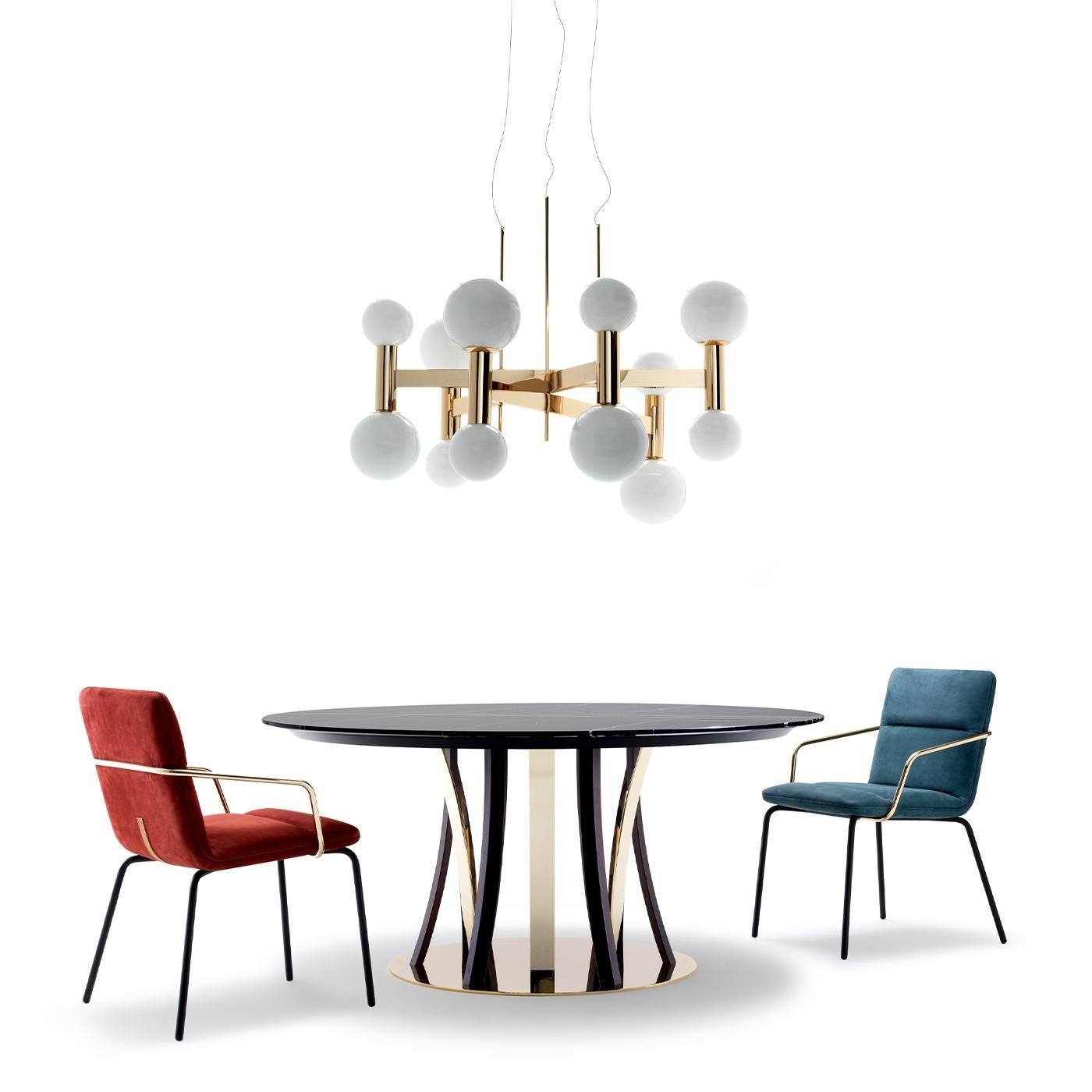 A sculptural objet d'art, this splendid dining table is a unique design by Castello Lagravinese Studio. Boasting a captivating interplay of refined materials, it is composed of dark American walnut and satin brass-finished metal legs interacting in