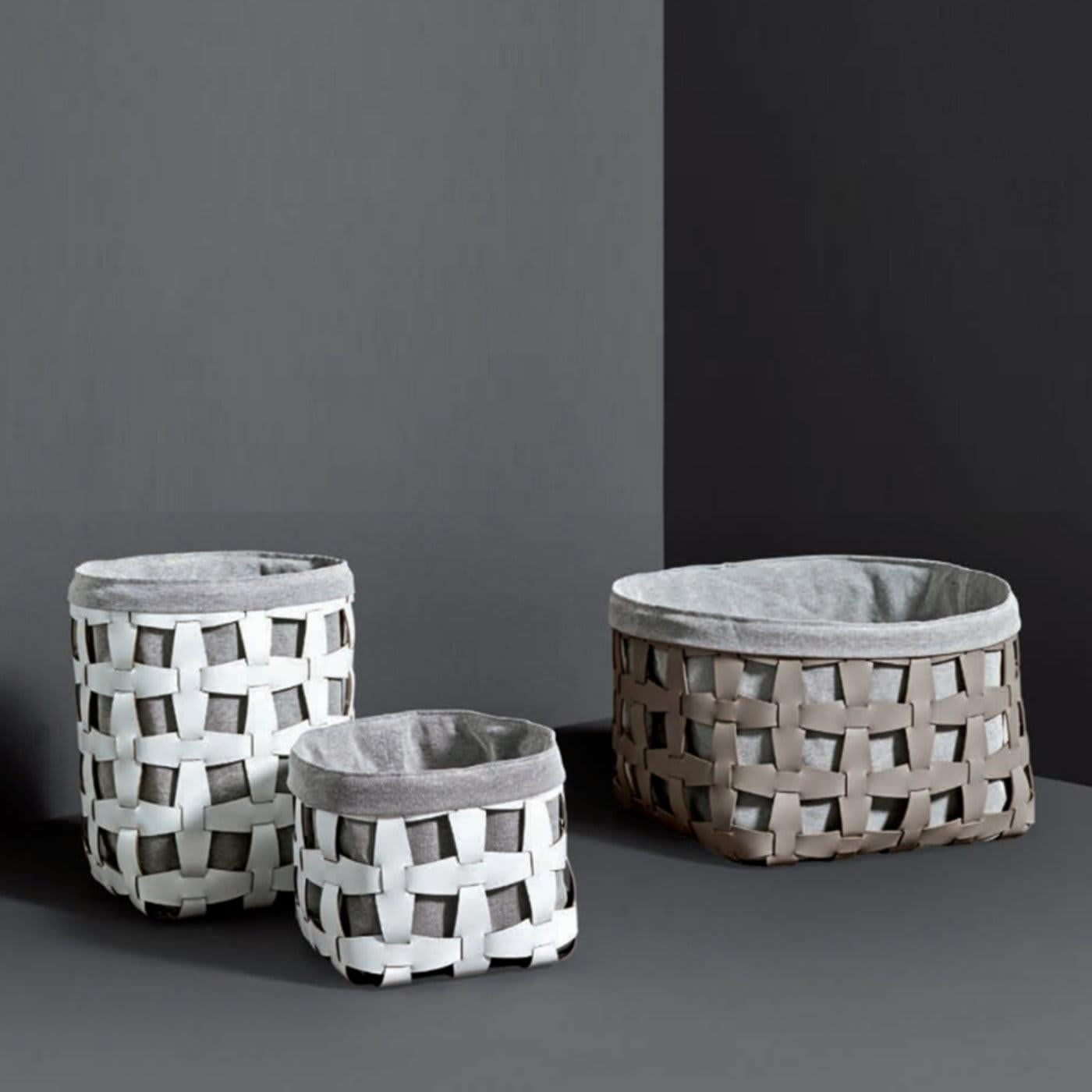 This elegant basket is part of the Hook collection, featuring containers of different sizes that can be used to store everyday objects both indoors and outdoors. Its shell is made of reconstituted leather in a shade of beige (available in other hues