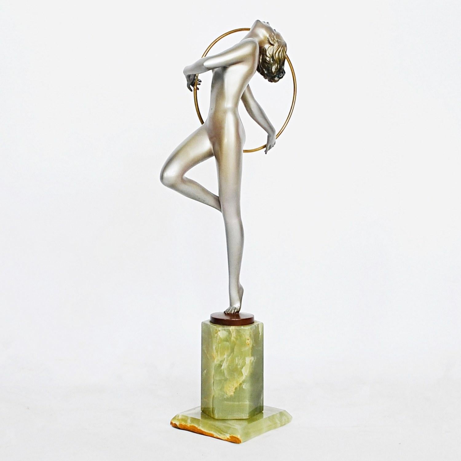 Hoop dancer, a large Art Deco, cold painted silvered bronze figure by Josef Lorenzl (1892-1950). A dancing woman in stylized pose holding a golden hoop, set over a green onyx plinth. Signed Lorenzl to bronze

Excellent original