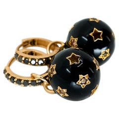Orecchini a cerchio con sfera smaltata nera, diamanti neri, stella e motivo celeste
