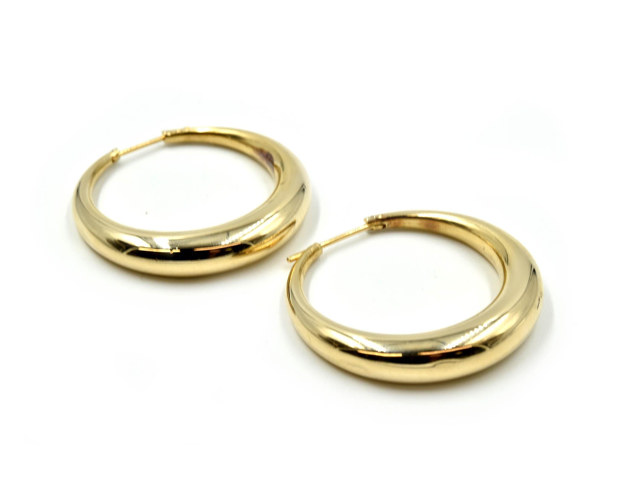 Designer: custom design
Material: 14k yellow gold
Dimensions: each hoop measures 1 1/2-inches in diameter
Fastenings: snap closures
Weight: 10.10 grams
