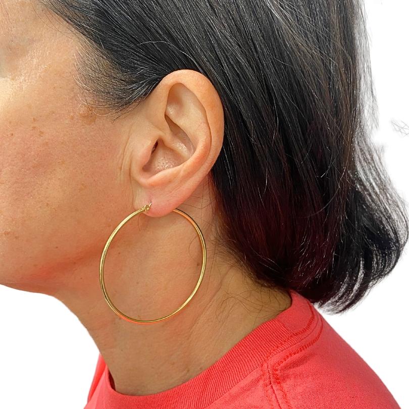 Questi orecchini a cerchio in oro 14k sono progettati con un look semplice e pulito. La superficie in oro lucido conferisce una finitura liscia e la dimensione media li rende facili da indossare ogni giorno. La loro forma è classica e versatile e li
