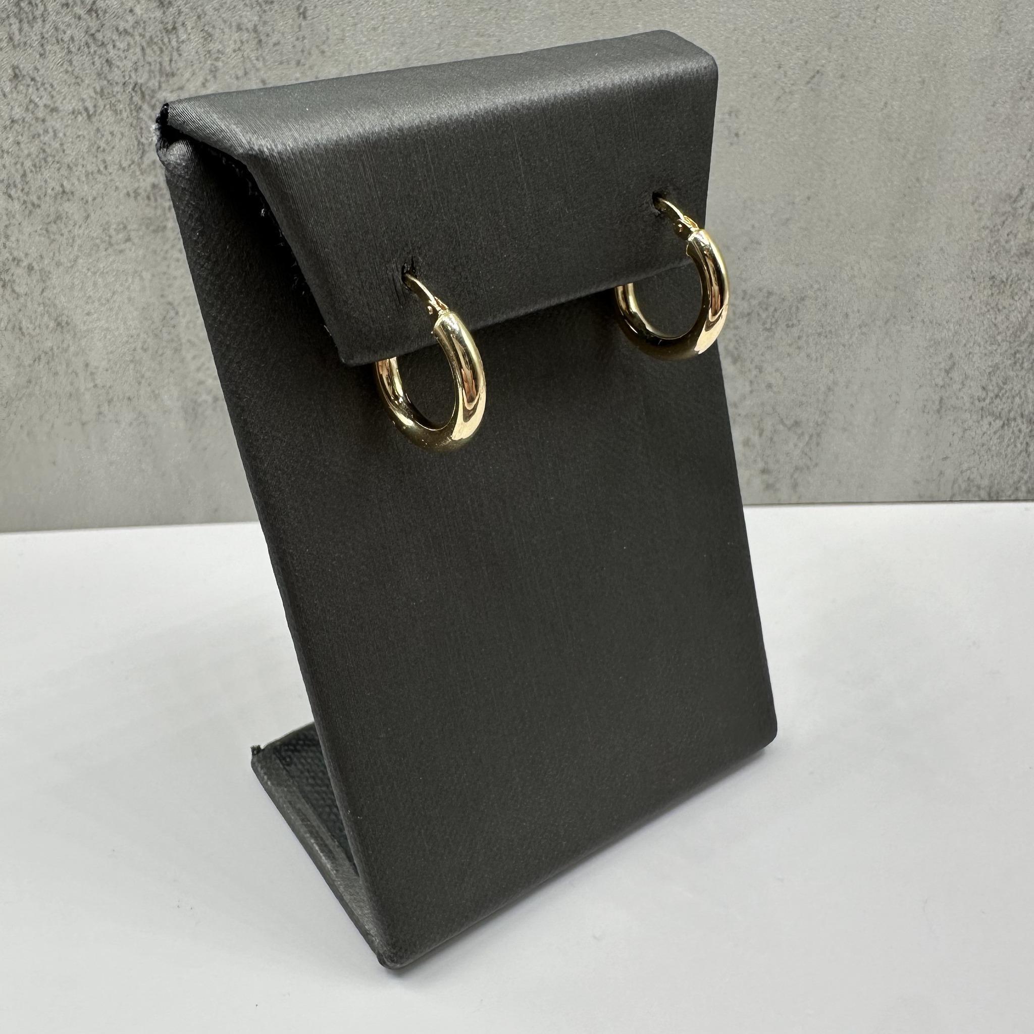 Ces boucles d'oreilles classiques en or jaune 14kt présentent un design poli et intemporel, parfait pour un usage quotidien. D'un diamètre extérieur de 16 mm et d'une largeur de 2,9 mm, elles offrent un profil élégant mais perceptible qui