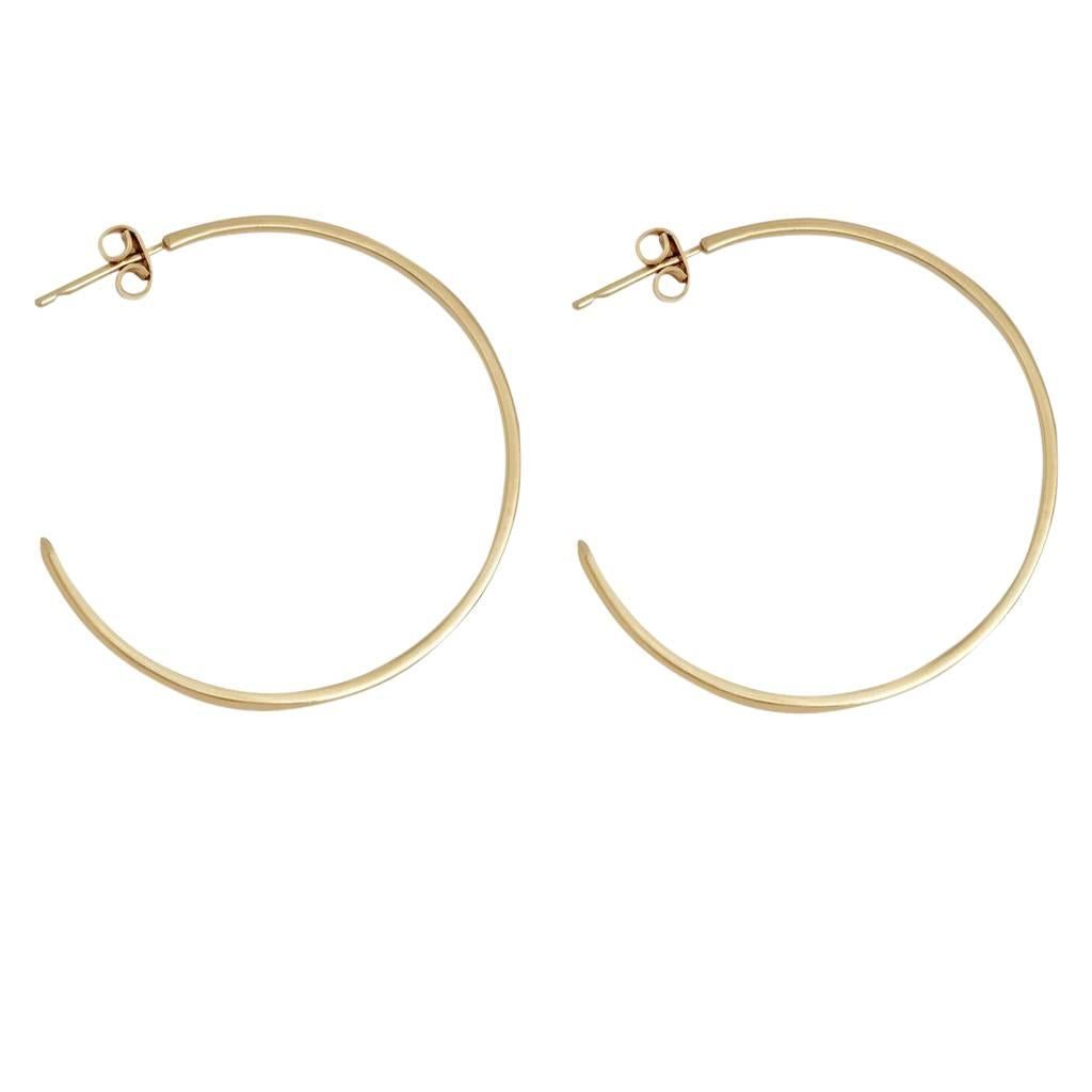 Classic hoop earrings featuring petite white diamond accents.  Crafted in solid 9-carat yellow gold, each hoop features two discreetly set white diamonds and a post and butterfly closure.  Measuring approximately 4cm in diameter, total carat weight