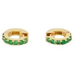 Huggy Hoop Earrings with green gems in 14k gold 