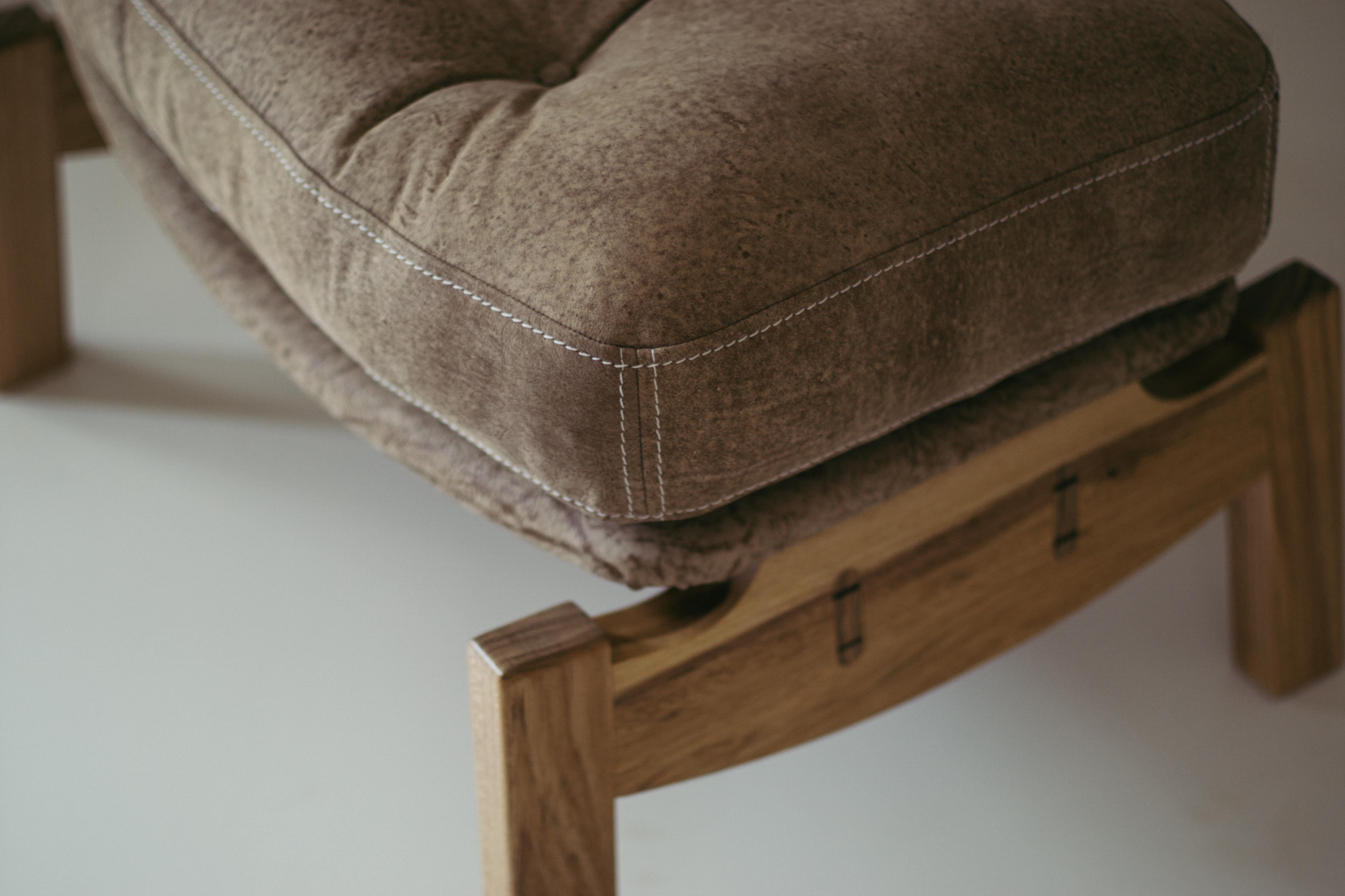 The Hoop footstool is made of solid wood, upholstered in natural leather.