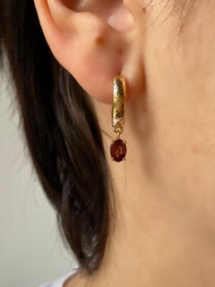 Pendientes de aro martillado de oro amarillo de 18 kt con granate de Rossella Ugolini Made in Italy