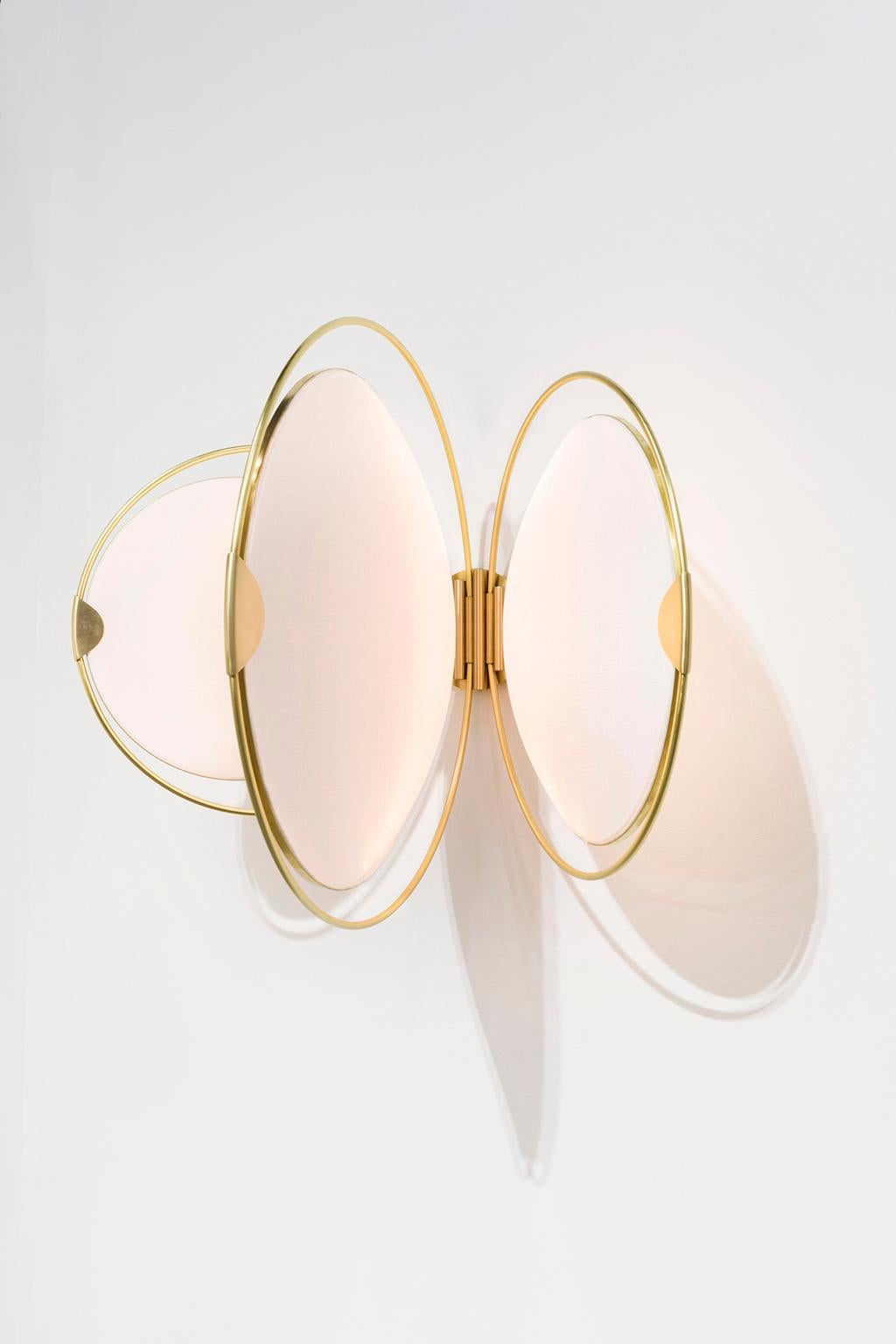 The Hoop Shade was inspired by the construction and dynamic motion of hoop skirts from the early 1900s. The large brass hoops rotate back and forth, and the shades rotate within those hoops, allowing the user to adjust the light to their needs.