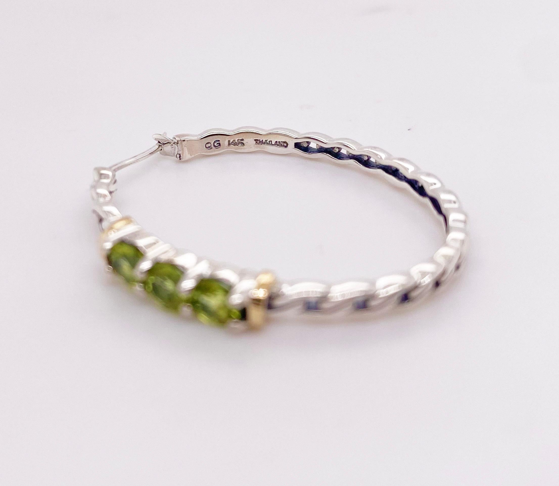The details for these gorgeous earrings are listed below:
Metal Quality: Sterling Silver
Earring Type: Hoop 
Gemstone: Peridot 
Gemstone Weight: .22 ct
Gemstone Color: Green 
Measurements: 3 cm X 3.5 cm
Band Width: 2.3 mm 
Post Type: Lever 
Total