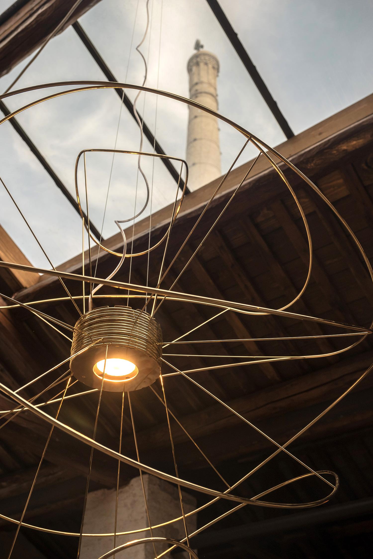 Hoops is defined first its direct/indirect lighting elements which illuminate the ceiling as well as below; then by the swirling ligatures of handcrafted metal which envelop the center and cast dramatic forms of shapes and light.

Inspired by the