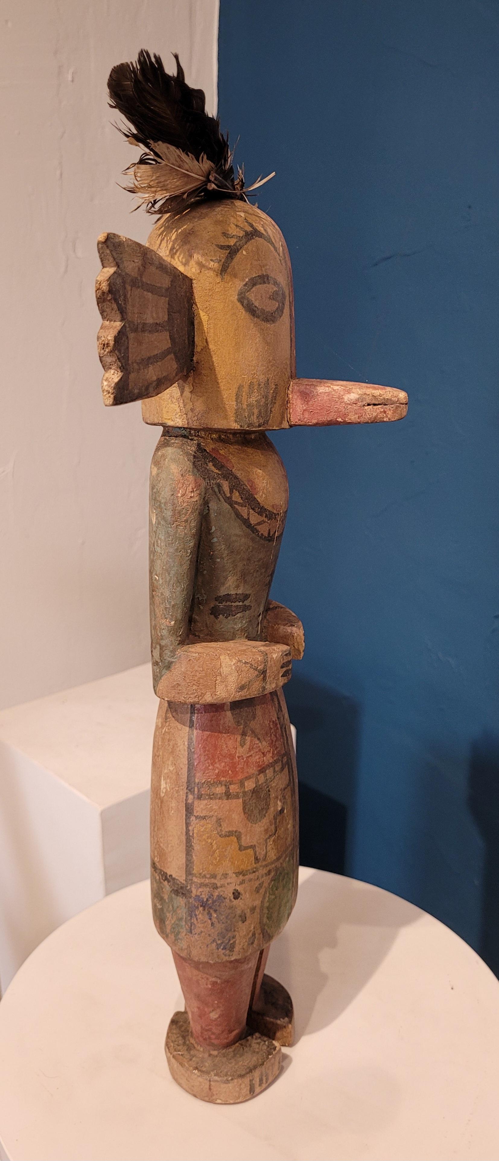 Figura efigie nativa norteamericana tallada en madera y pintada, muñeca Hopi Katsina o Kachina. 

Una muñeca Hopi Katsina maravillosamente juguetona, coloreada y muy individual. Cada muñeca representa un espíritu o elemento diferente.

Cada muñeca
