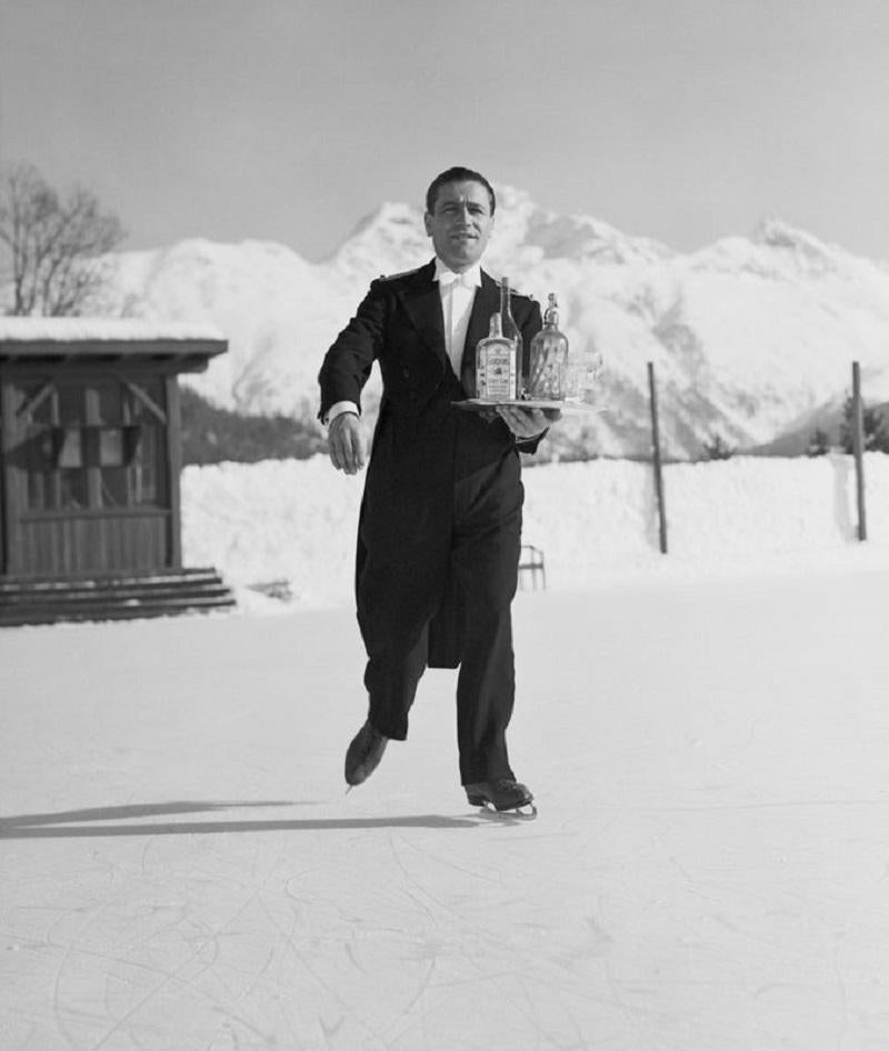 "Skating Waiter" by Horace Abrahams

8th January 1938: A waiter skates across the ice at St. Moritz carrying a tray of drinks for his customers. 

Unframed
Paper Size: 60" x 40'' (inches)
Printed 2023
Silver Gelatin Fibre Print