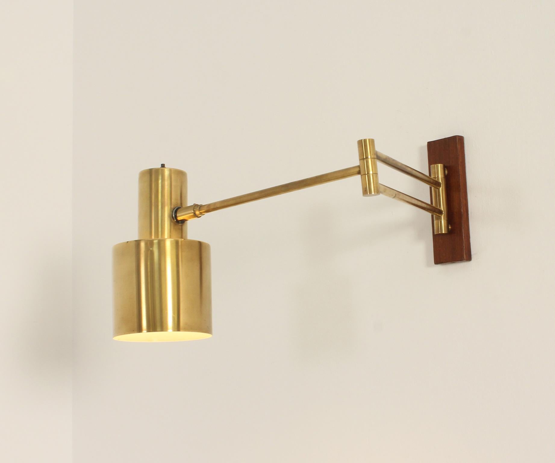 Lampada da parete Horisont disegnata nel 1969 da Jo Hammerborg per Fog & Mørup, Danimarca. Doppio braccio allungabile e riflettore in ottone con supporto in metallo rivestito in legno di teak. 