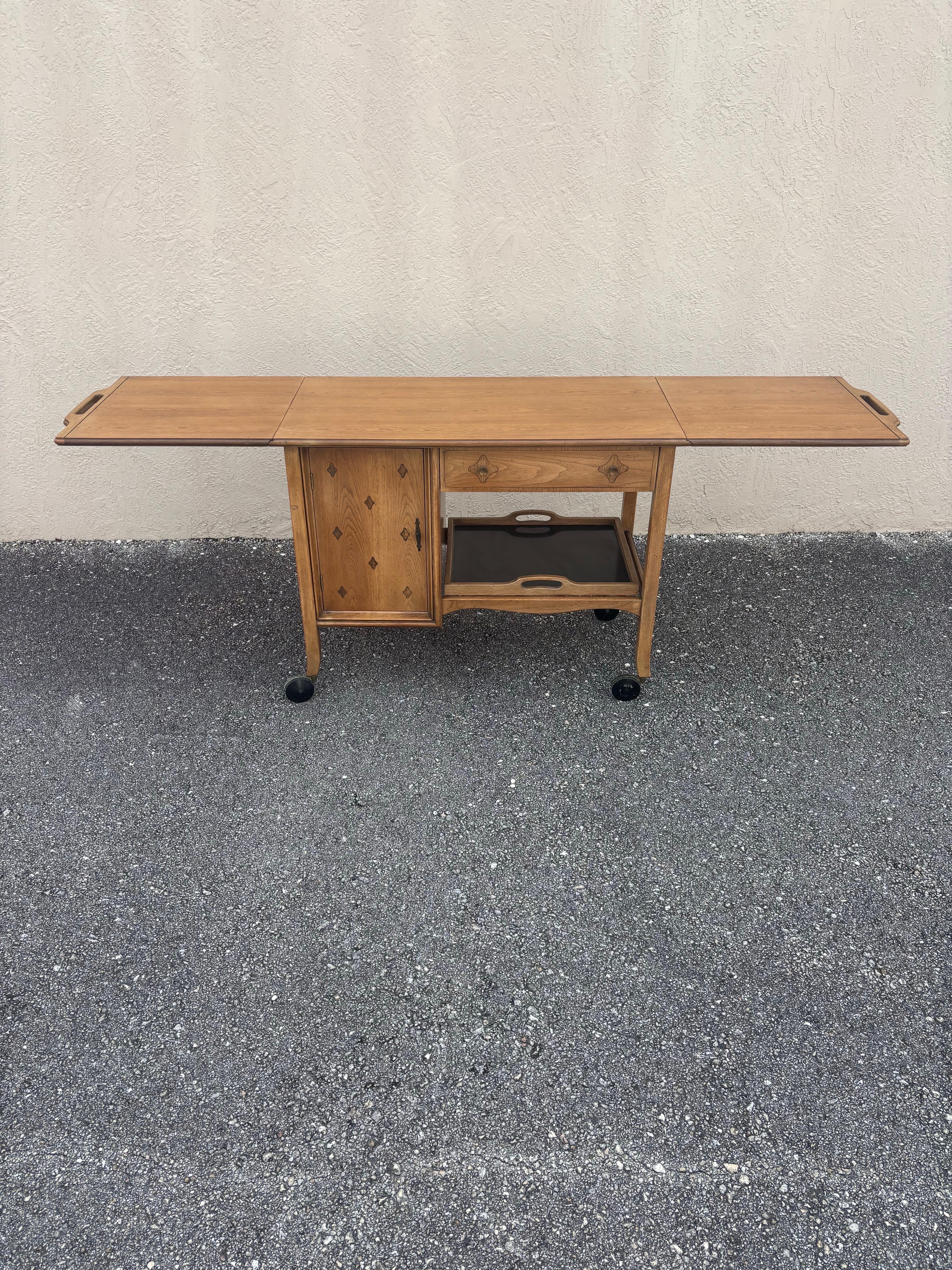 Carrito de bar Mid Century Modern fabricado por Thomasville para su línea Horizon. Luce su acabado original, que se ha decolorado de forma bella y natural con el tiempo. 

Este carrito de bar tiene un cajón grande, un armario con puerta, una bandeja