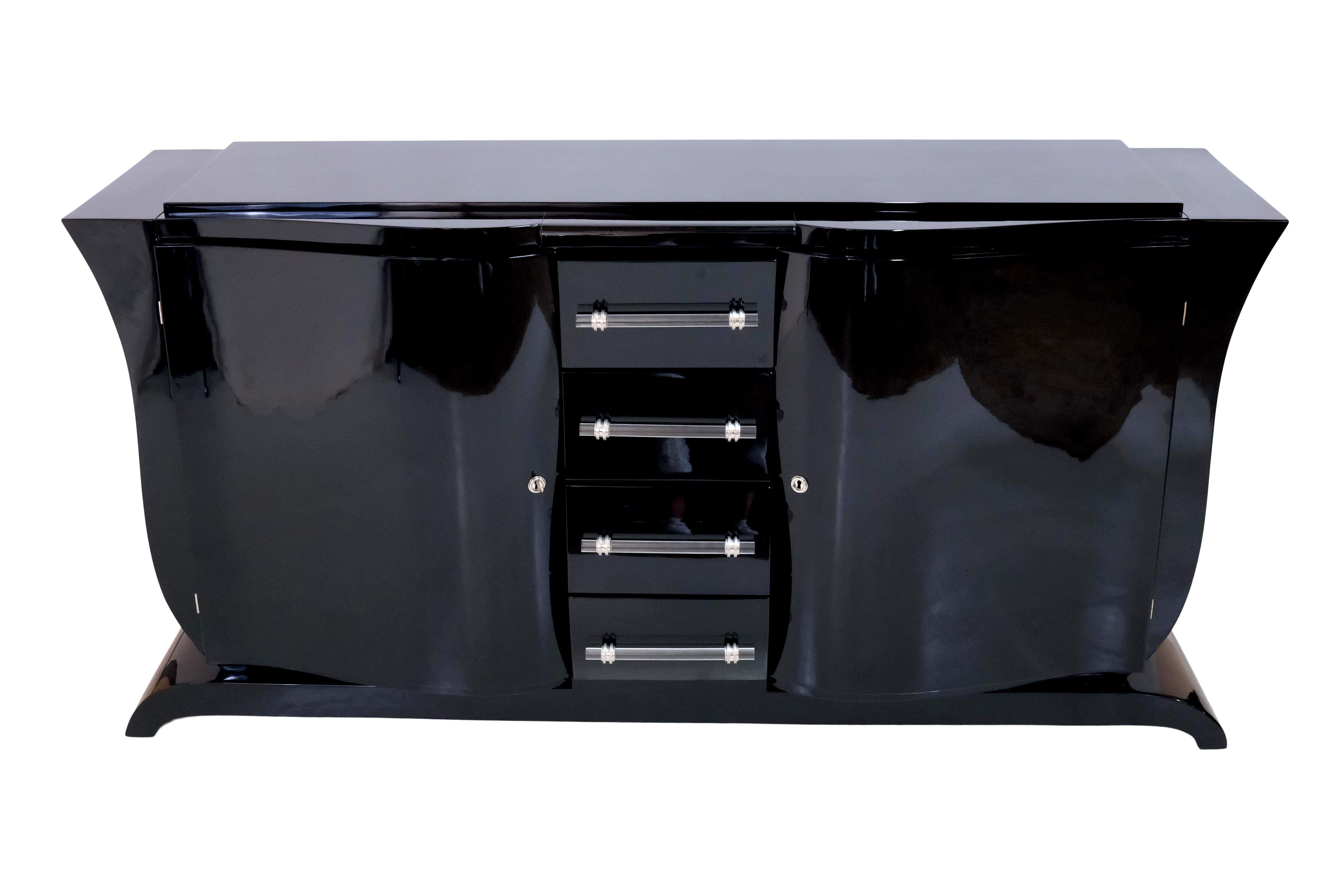 Sideboard with curved sides in typical shape.
The front is also curved both horizontally and vertically

Furniture in Black Lacquer, high gloss 

Two hinged doors,
drawers in the middle part,
Glass handles

Original Art Deco, France 1930s 

The