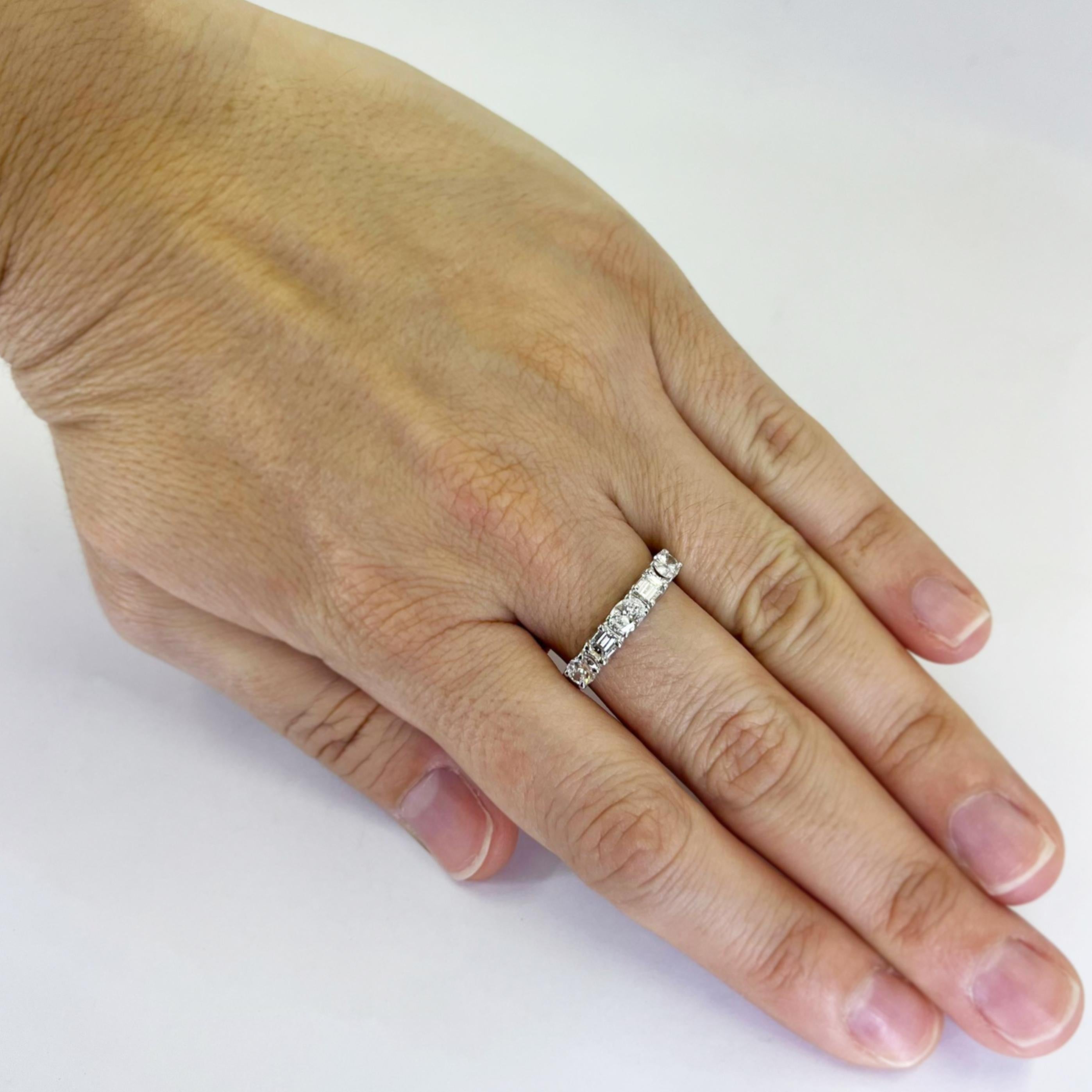 18 karat white gold east to west 5 stone ring featuring oval and emerald cut diamonds of VS clarity and H color totaling approximately 1.00 carat. Finger size 9; includes one sizing service upon request. Finished weight is 3.8 grams.