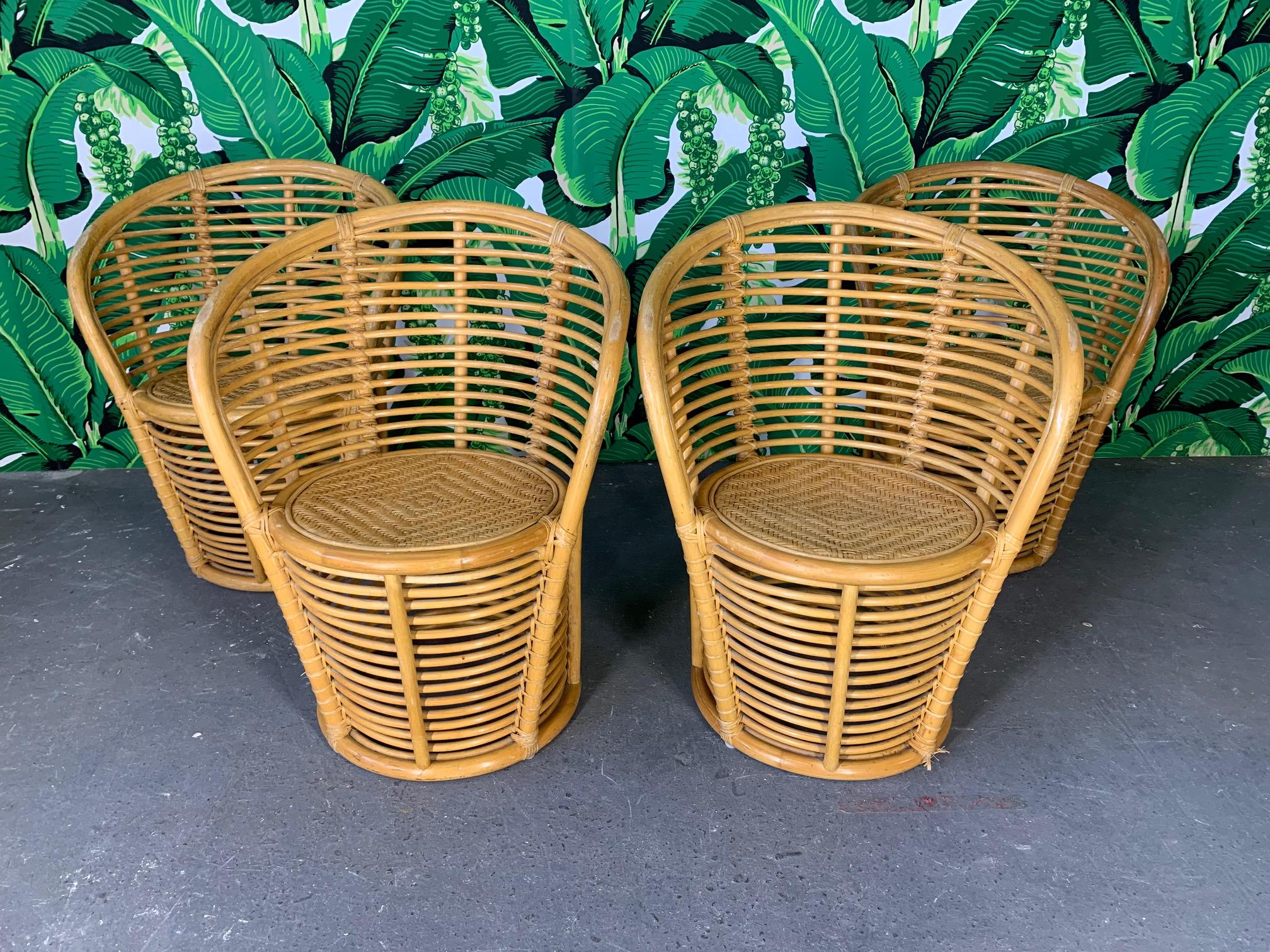 Rattan barrel dining chairs feature a unique horizontal rattan construction. Set of 4. Good condition with minor imperfections consistent with age, circa 1970s.