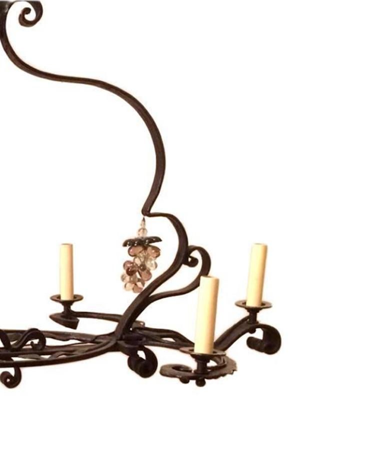 A French circa 1920s wrought iron chandelier with foliage details and grapes pendants.

Measurements:
Length 36