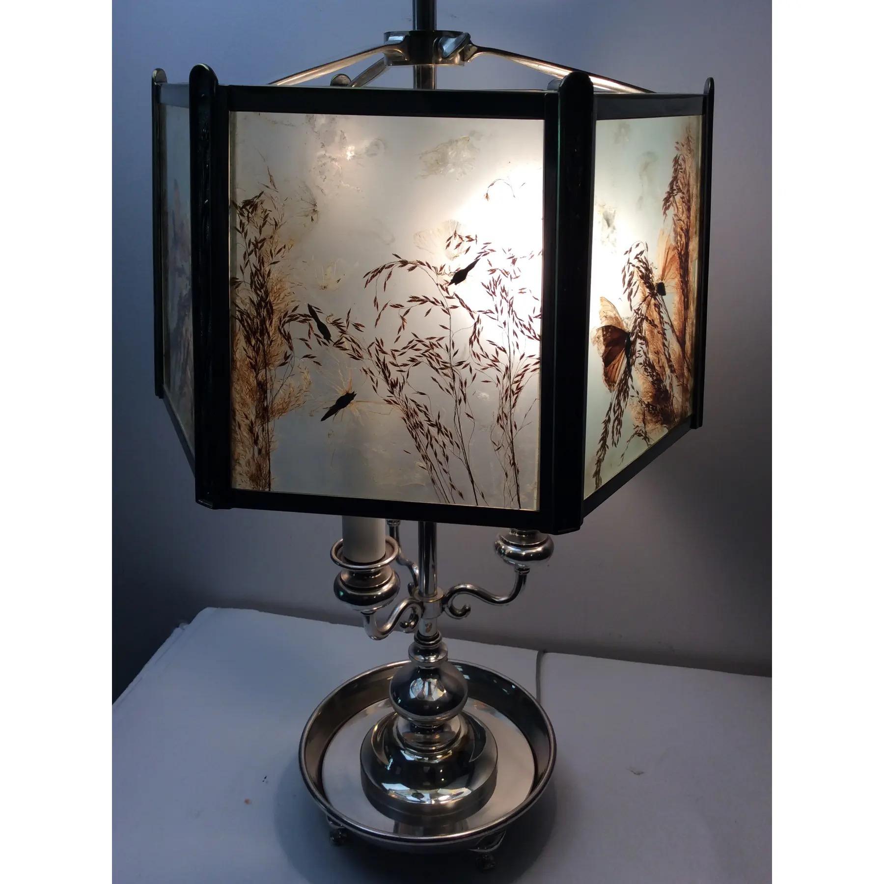 Lampe en métal argenté de Horn et Brannen. L'abat-jour hexagonal est encadré de panneaux avec des papillons et de la végétation naturelle sous verre. L'abat-jour est réglable.
